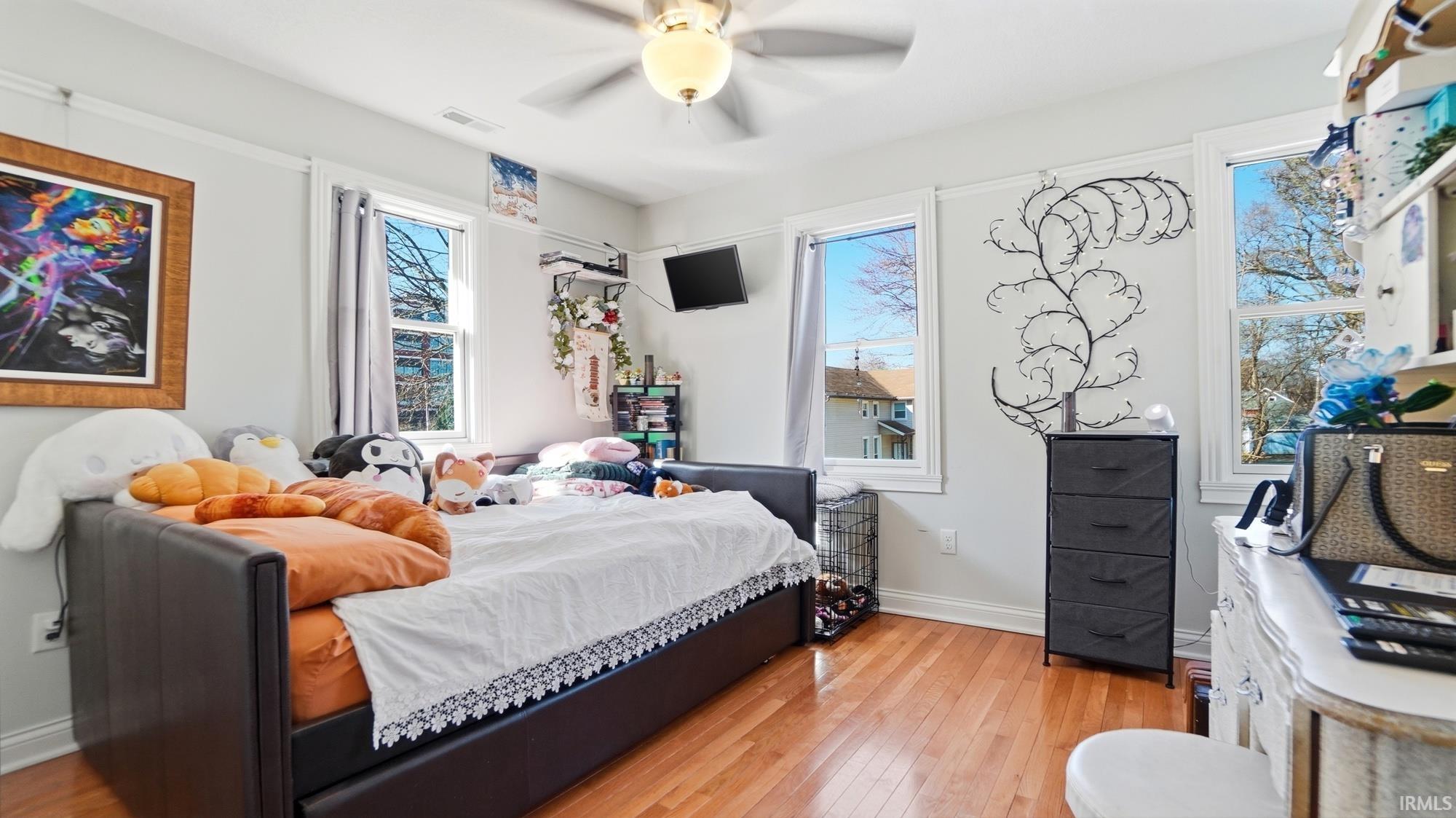 Bedroom with light wood finished floors and a ceiling fan