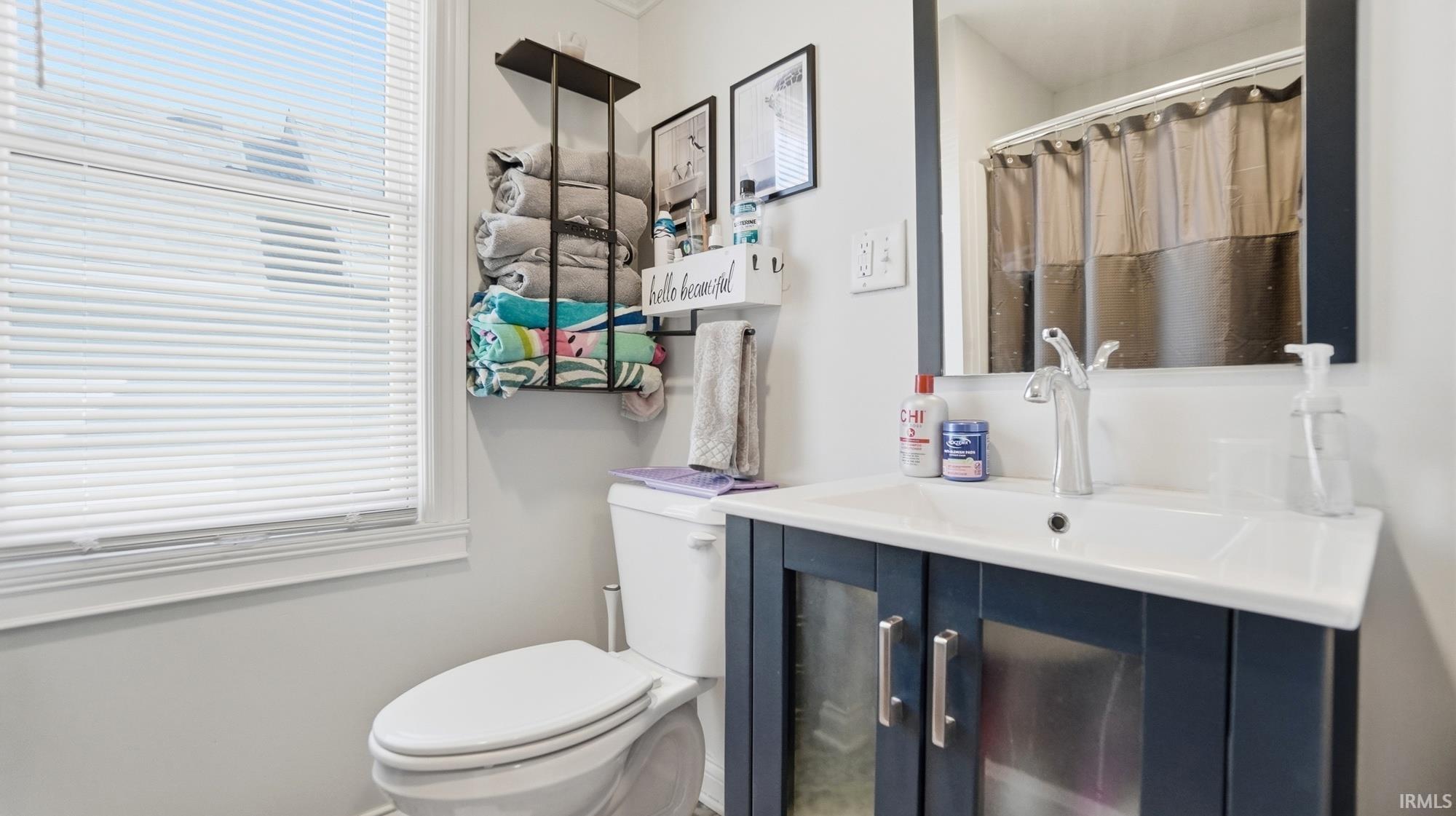 Bathroom with a shower with curtain, vanity, and healthy amount of natural light