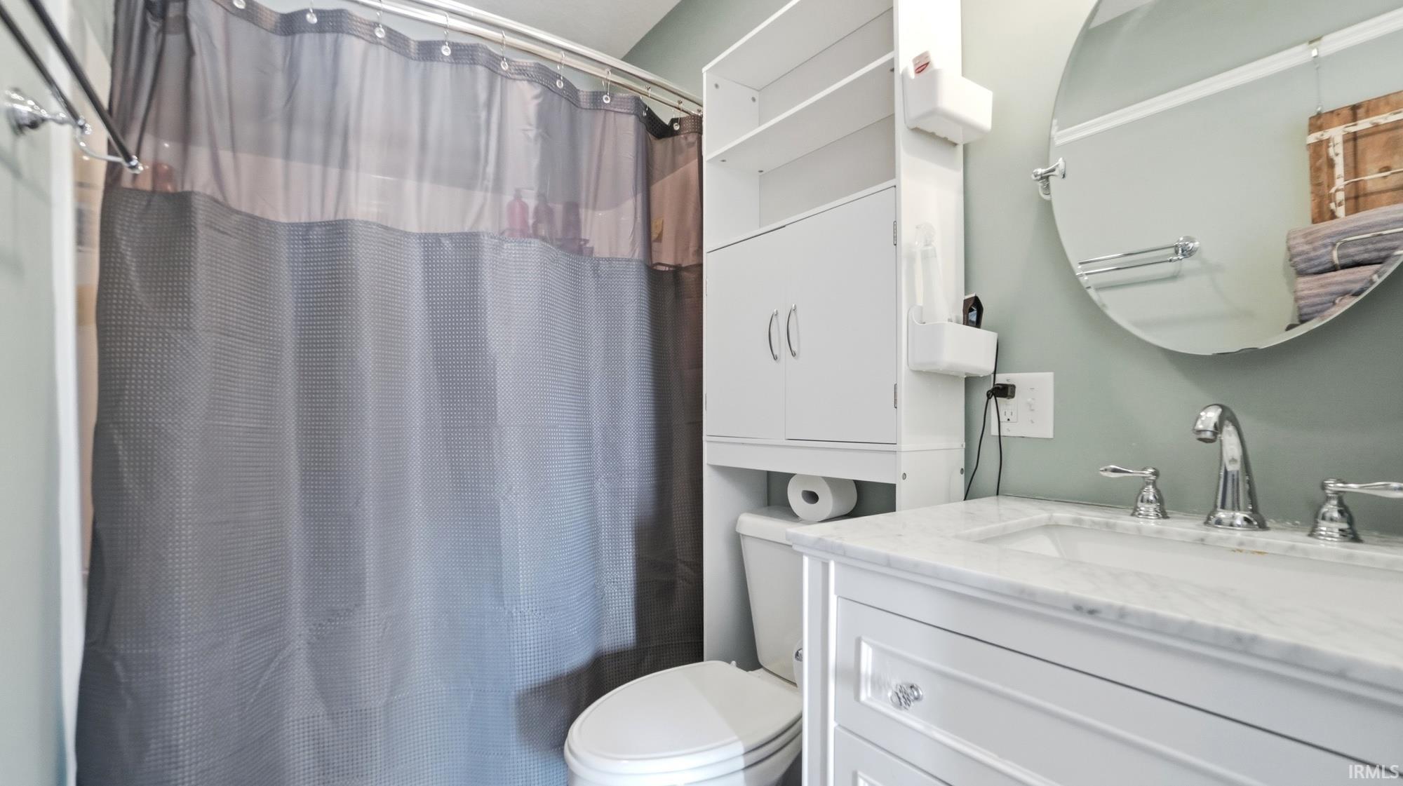 Full bathroom with vanity and a shower with curtain