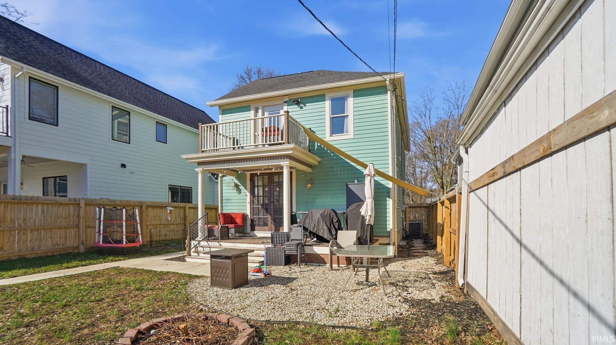 Rear view of property featuring a fenced backyard, a patio area, and a balcony