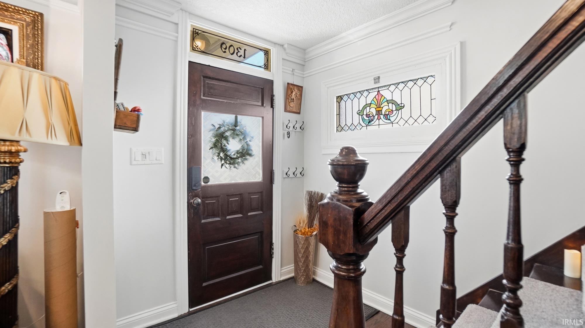 Foyer entrance with crown molding and well preserved staircase