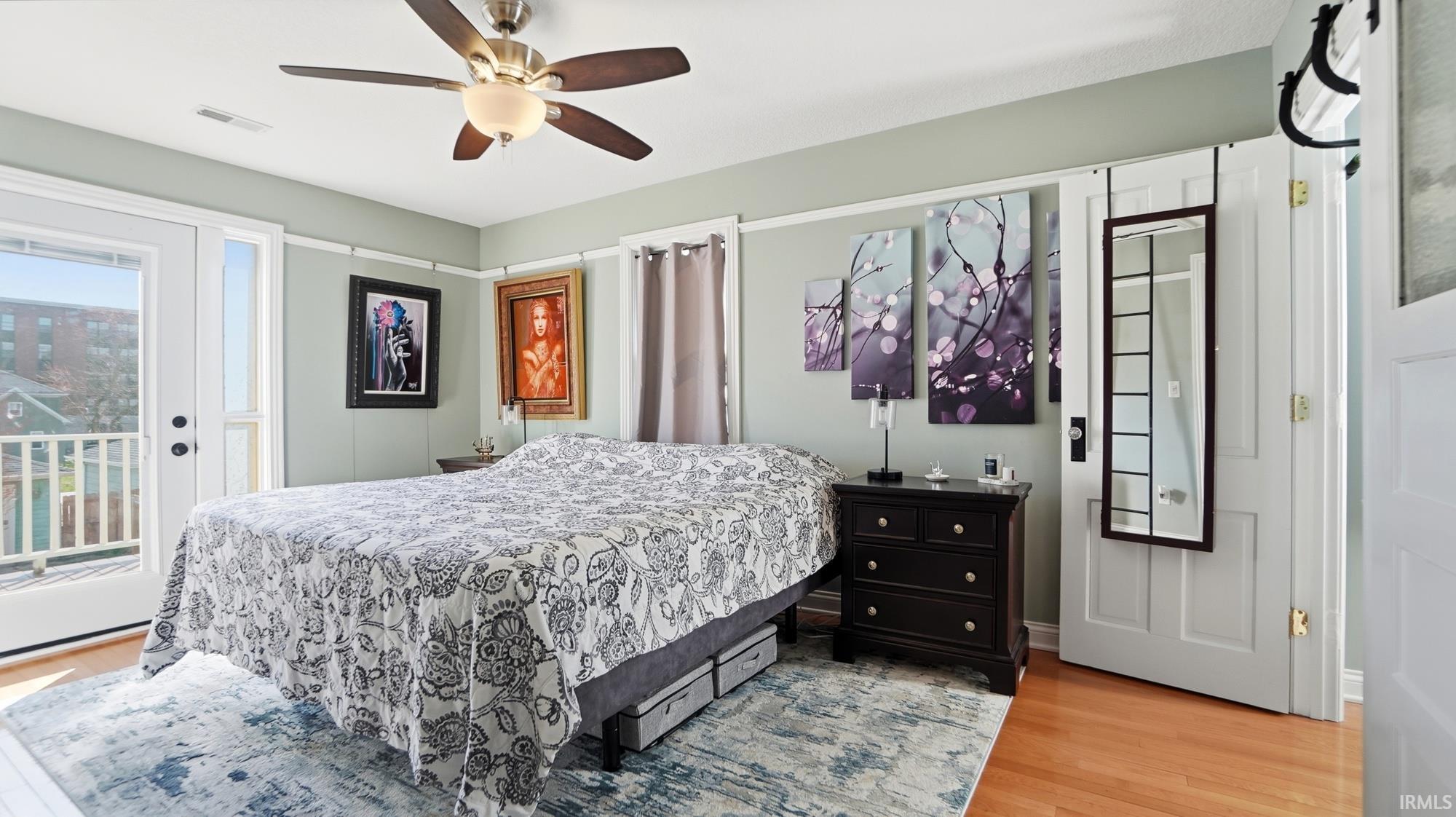 Bedroom with access to exterior, light wood-type flooring, and ceiling fan