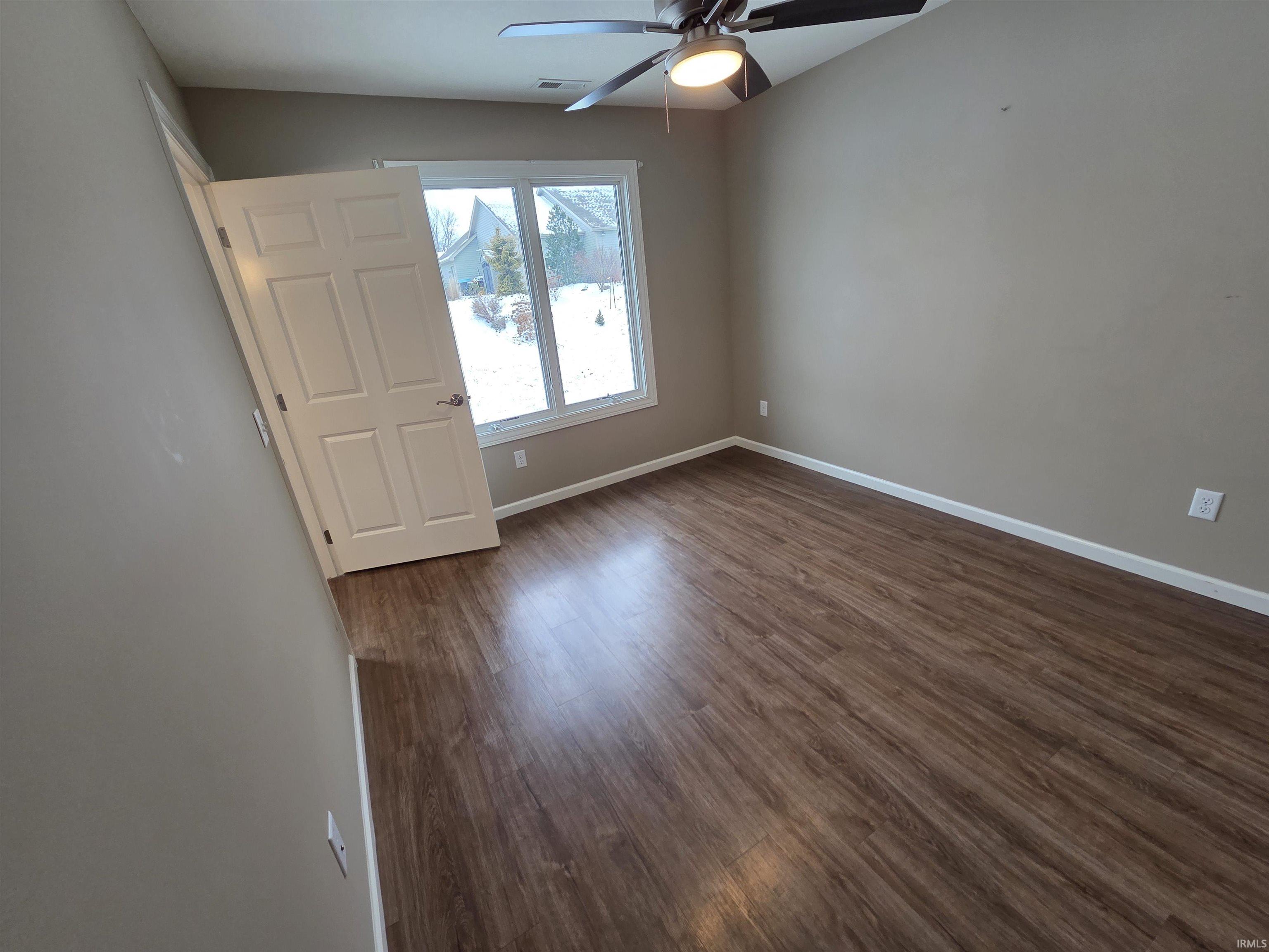 Spare room featuring dark wood finished floors and ceiling fan