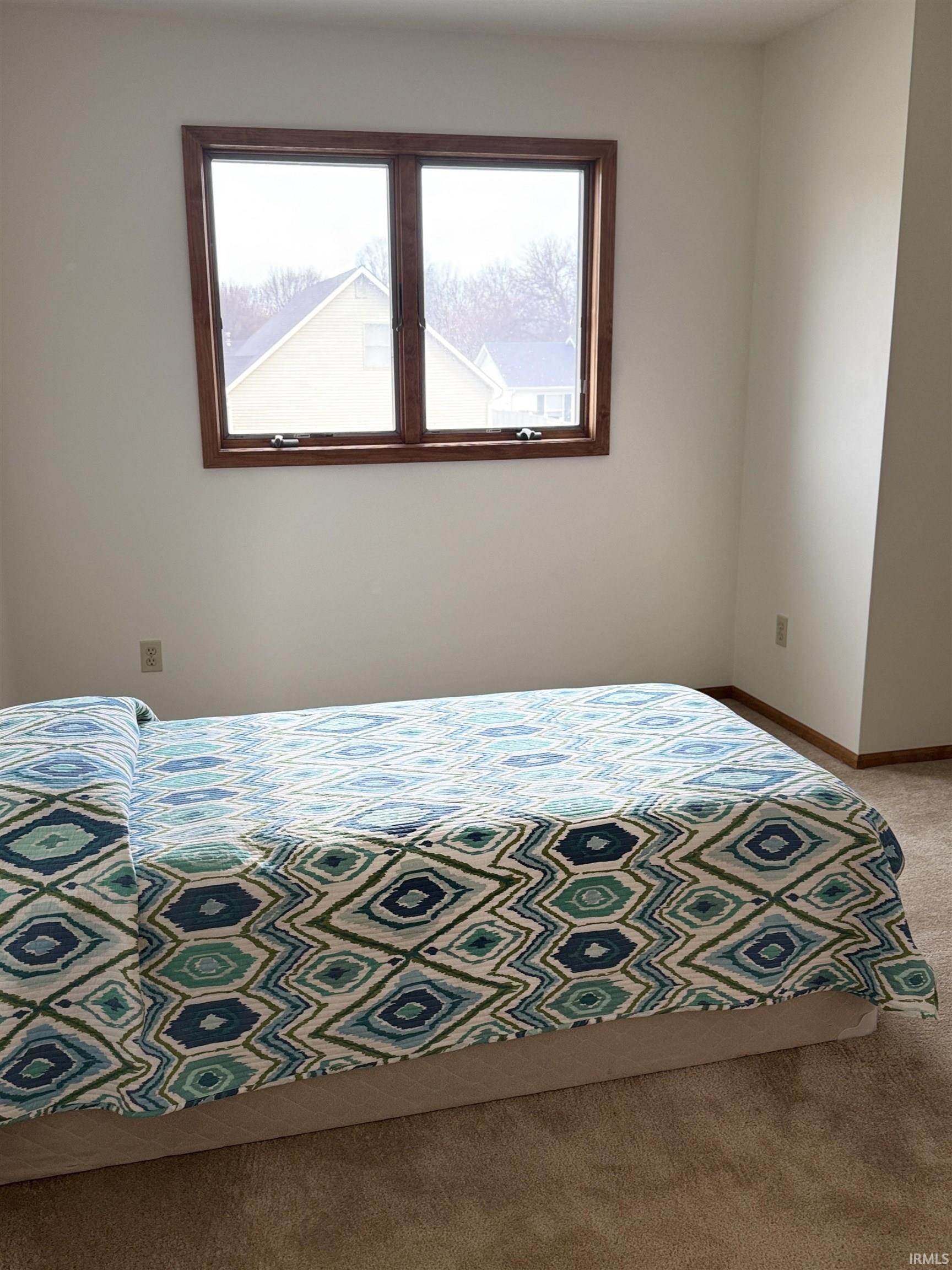 Bedroom featuring dark carpet and baseboards