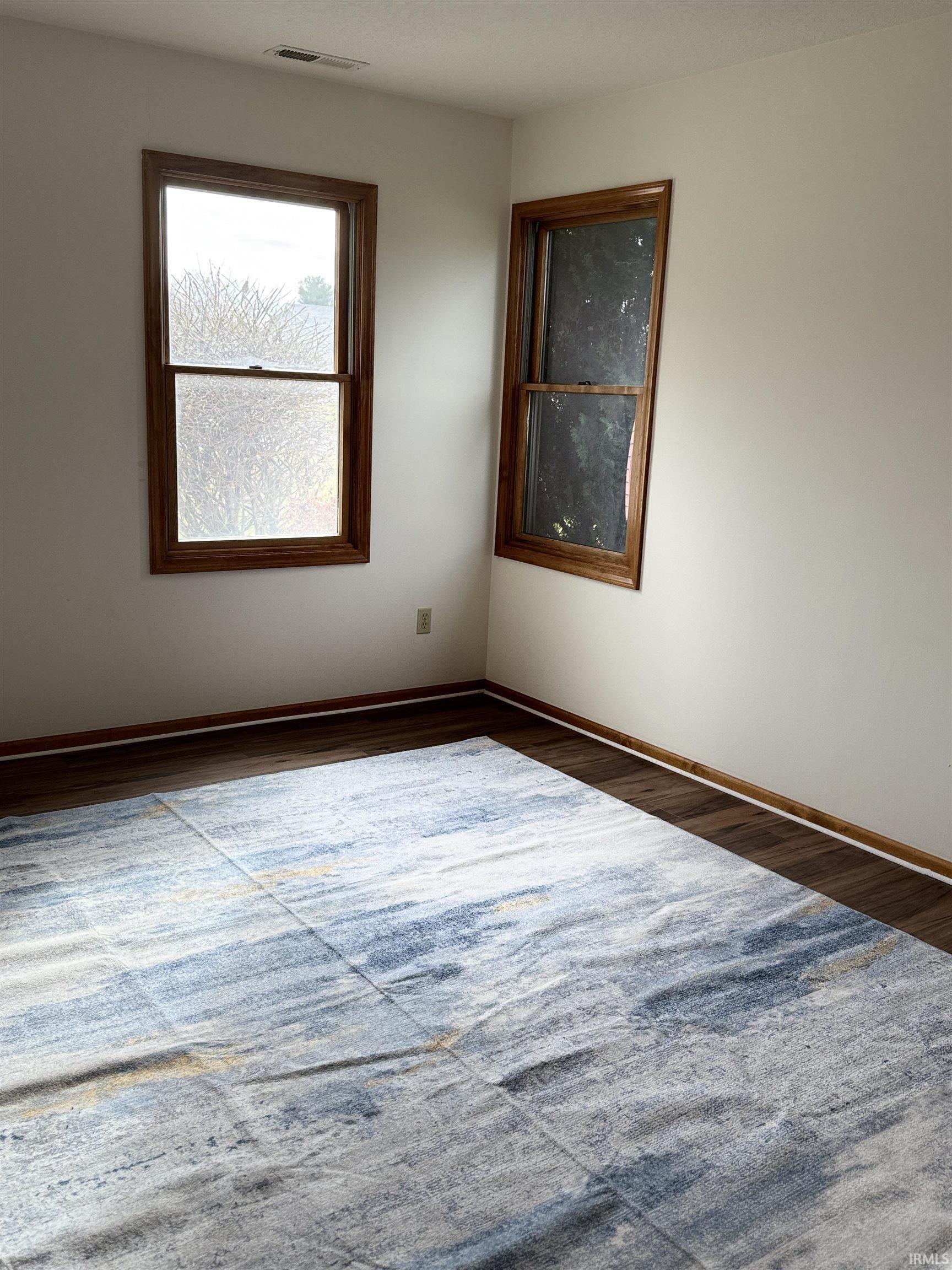 Spare room with dark wood-style floors