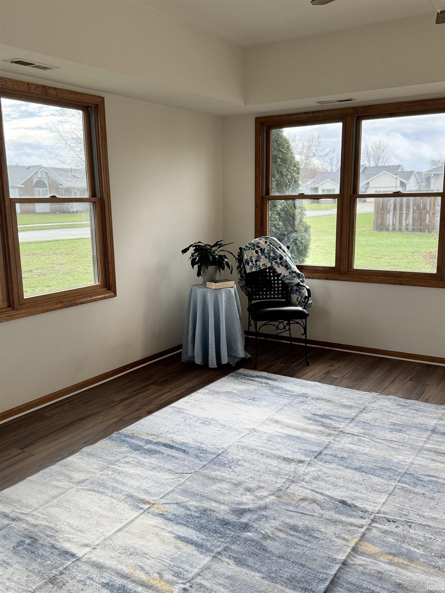 Unfurnished room with dark wood finished floors and a residential view