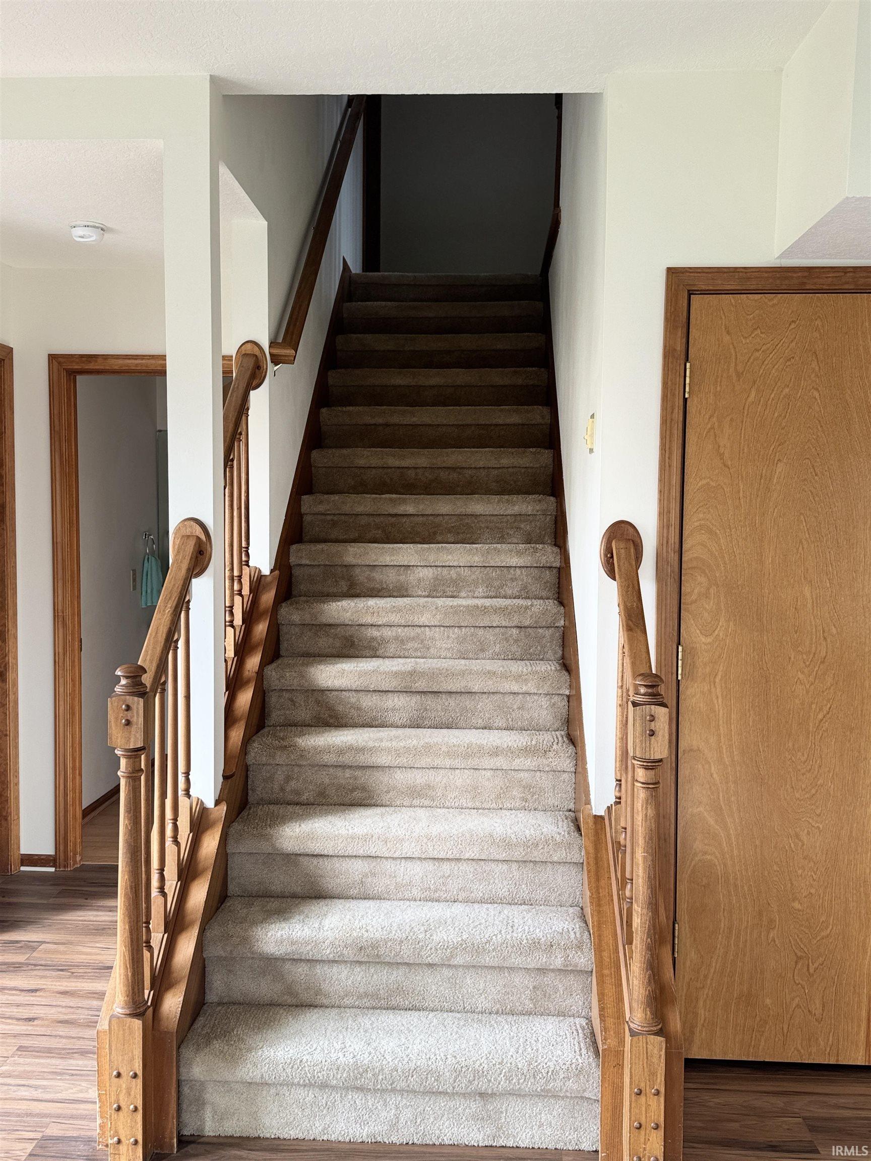 Stairway featuring wood finished floors