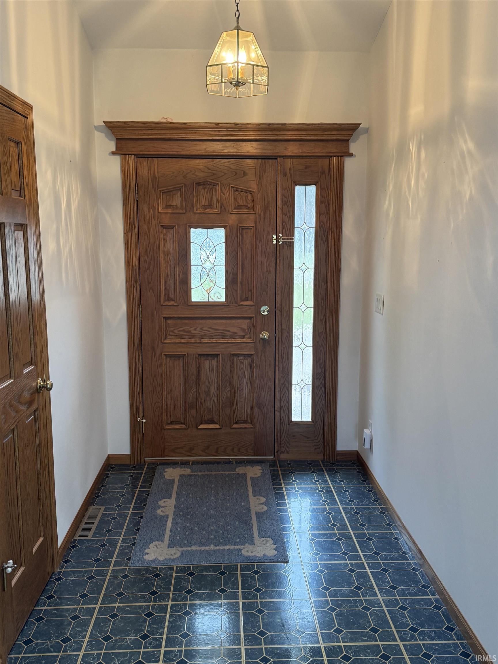 Entrance foyer with baseboards and dark flooring