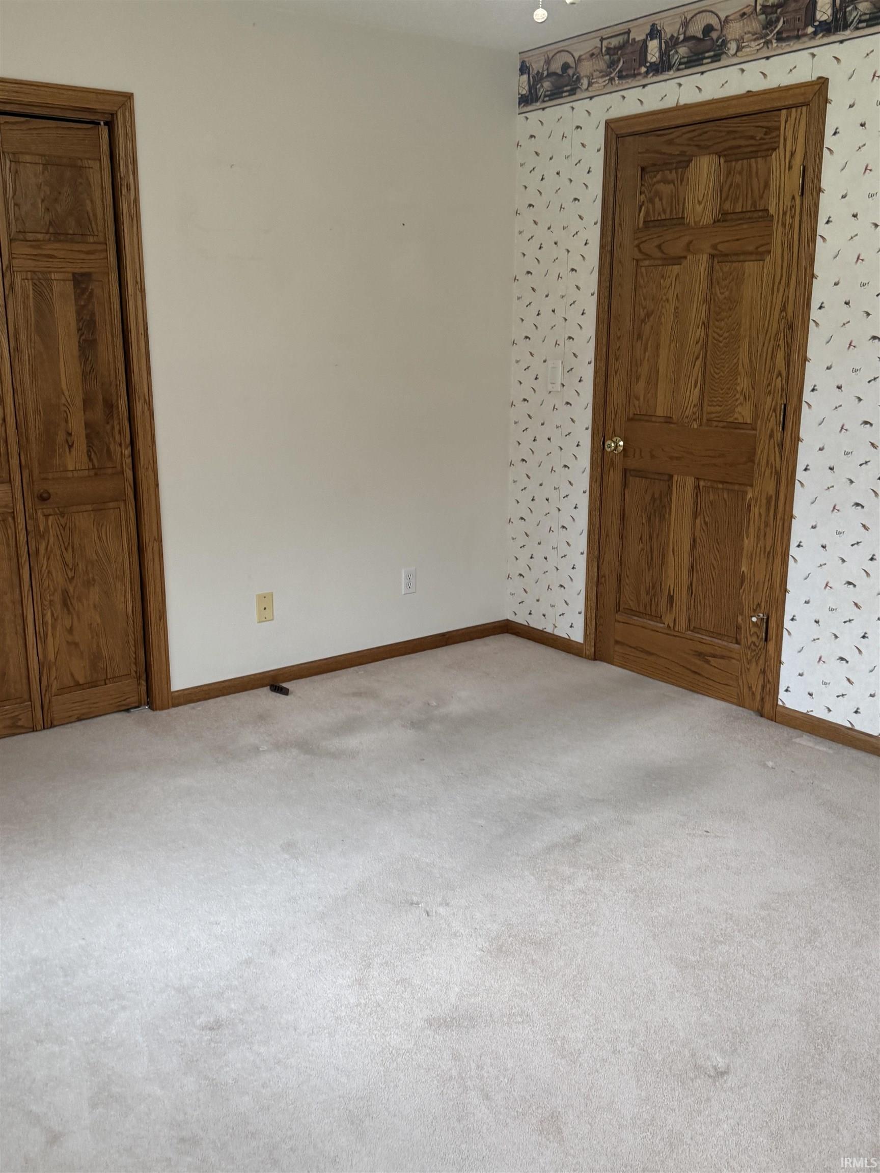 Spare room with light carpet and wallpapered walls