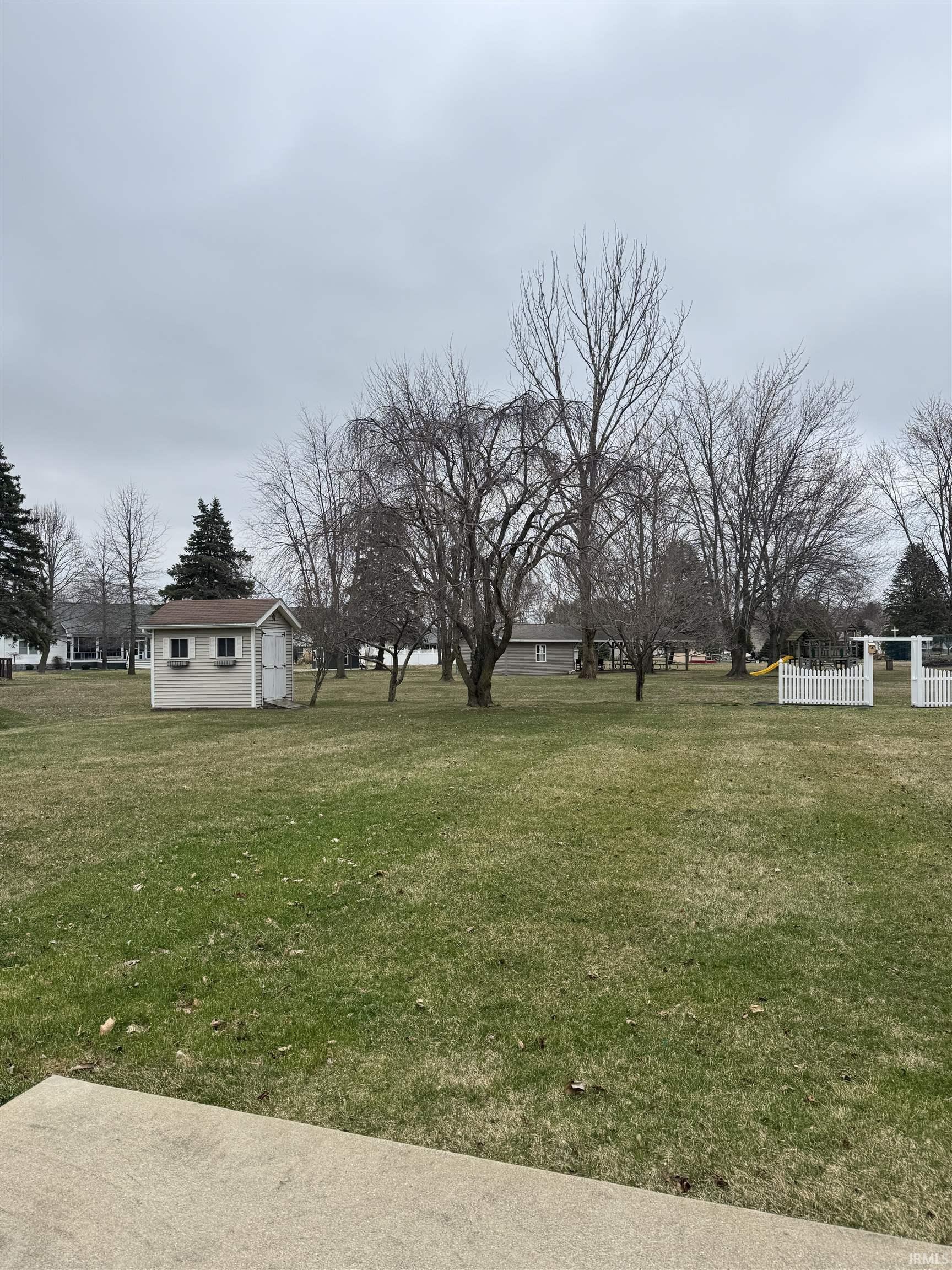 View of green lawn featuring an outbuilding