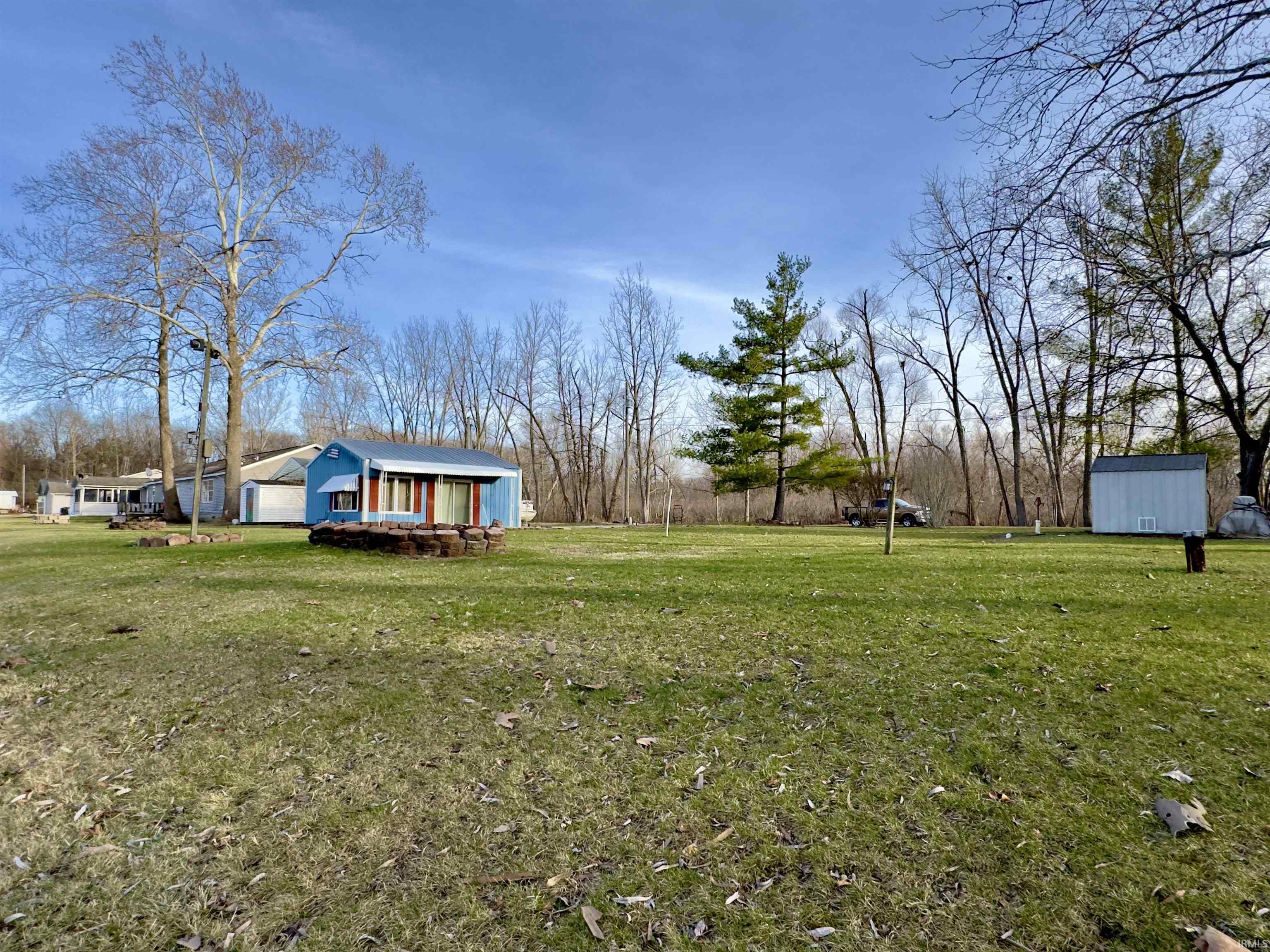 View of green lawn featuring a storage shed