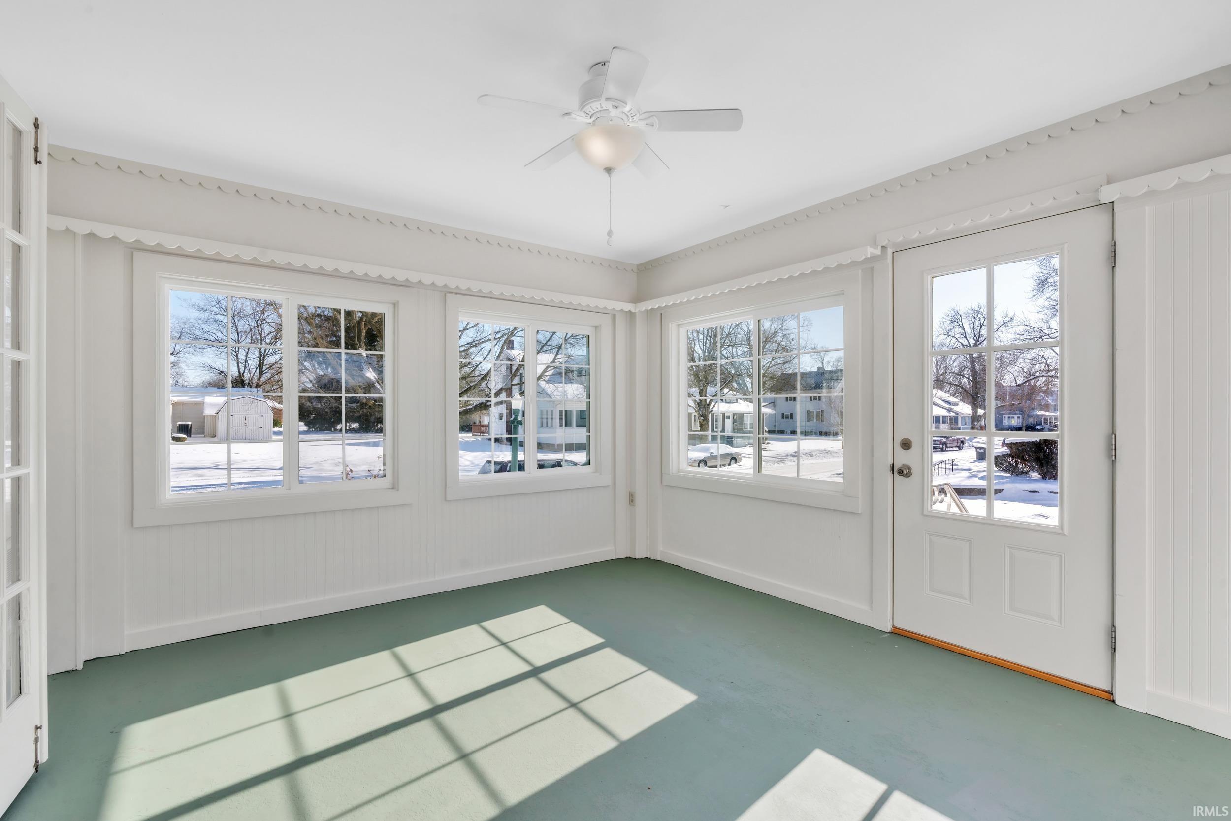 Unfurnished sunroom with healthy amount of natural light and finished concrete floors