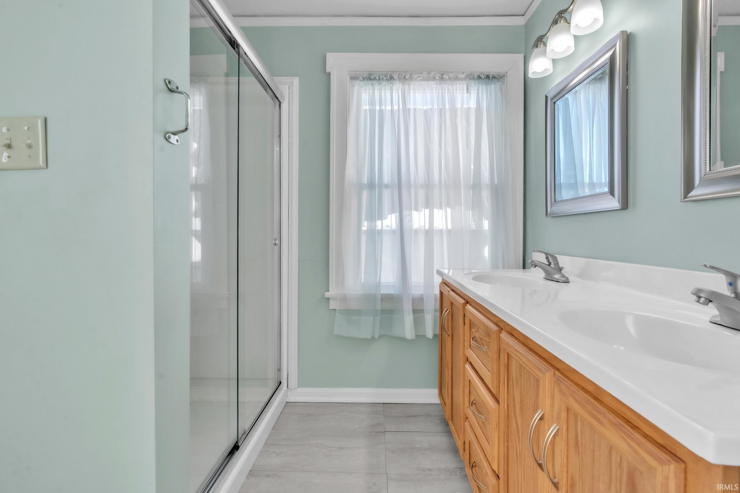 Full bathroom with double vanity and a shower stall