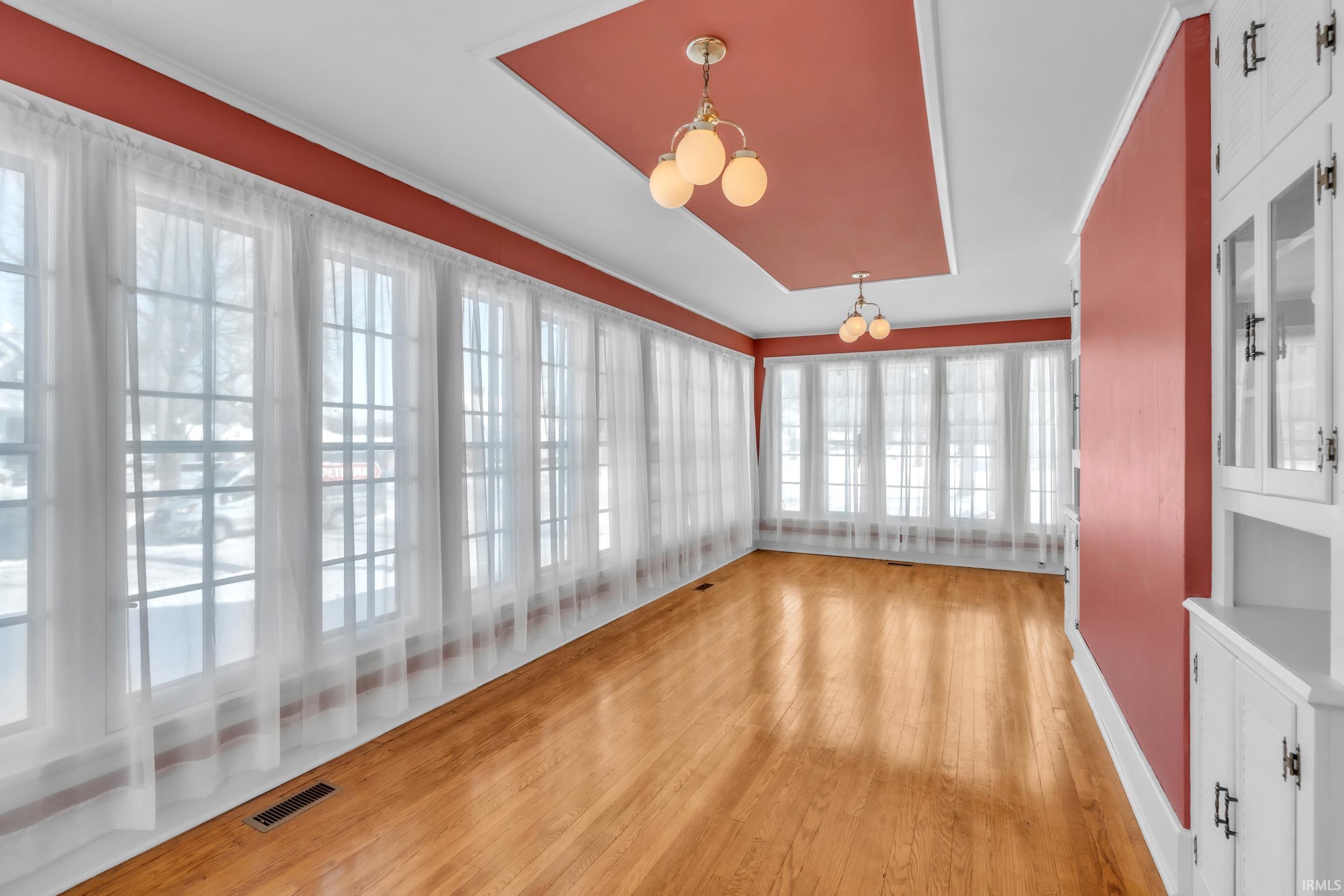 Unfurnished sunroom featuring wood finished floors and baseboards