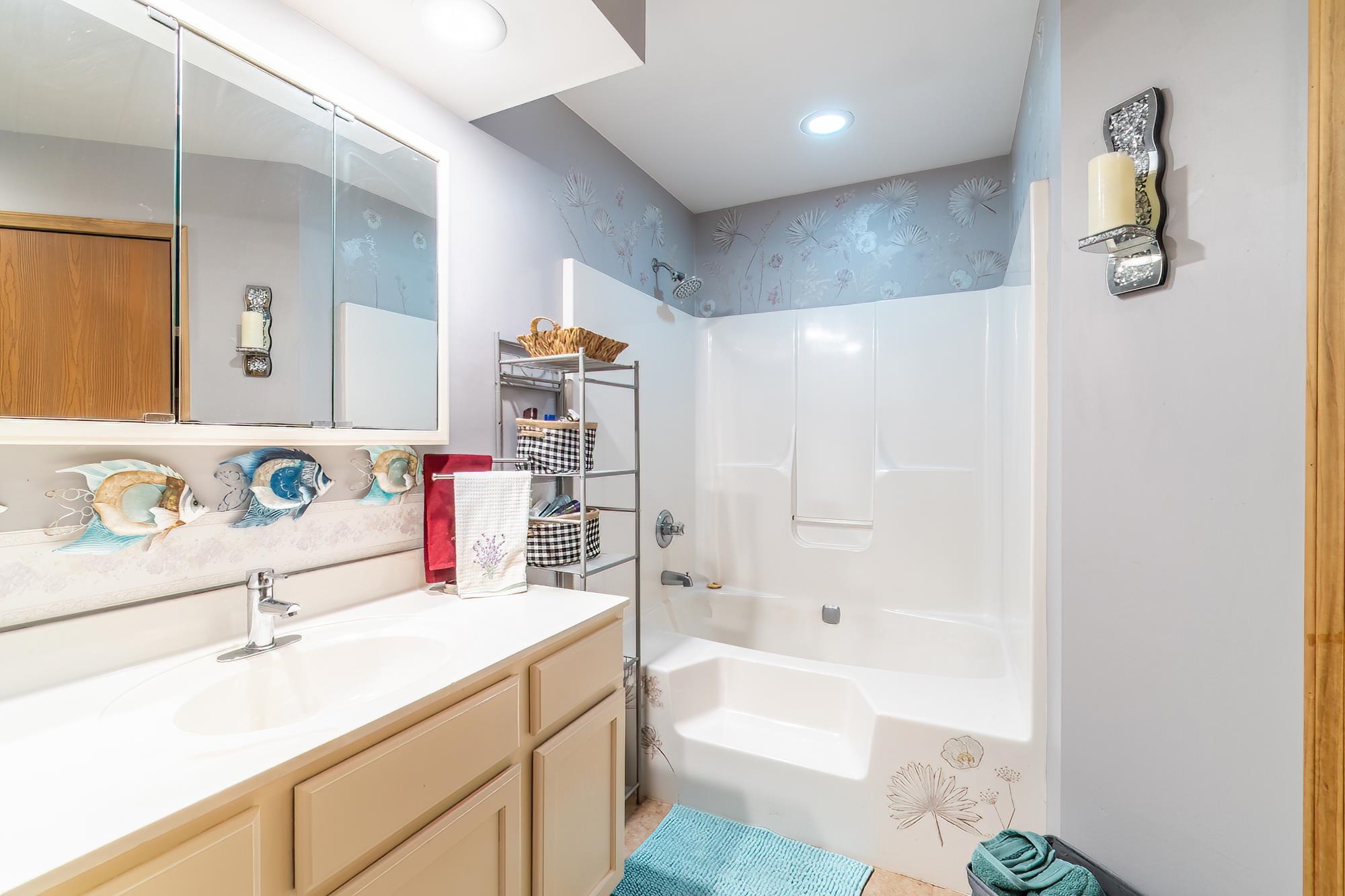 Full bath featuring vanity, tub / shower combination, wallpapered walls, and recessed lighting