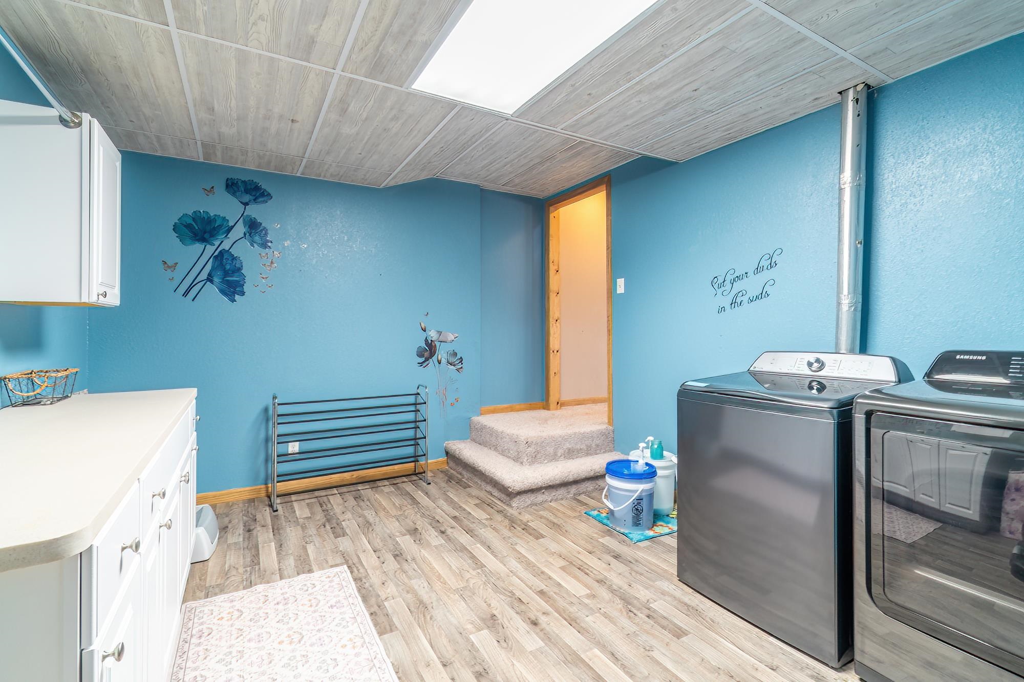 Laundry room featuring light wood-style flooring and washing machine and clothes dryer