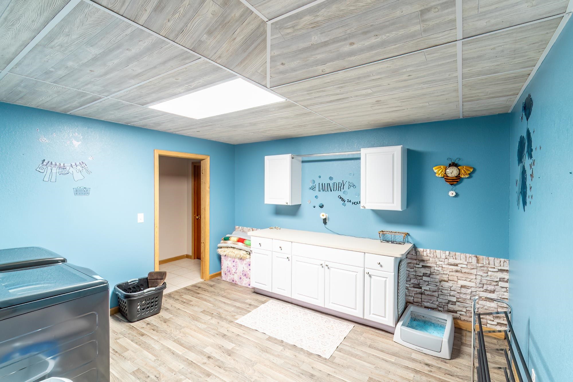 Laundry room featuring light wood-type flooring, washing machine and dryer, and cabinet space