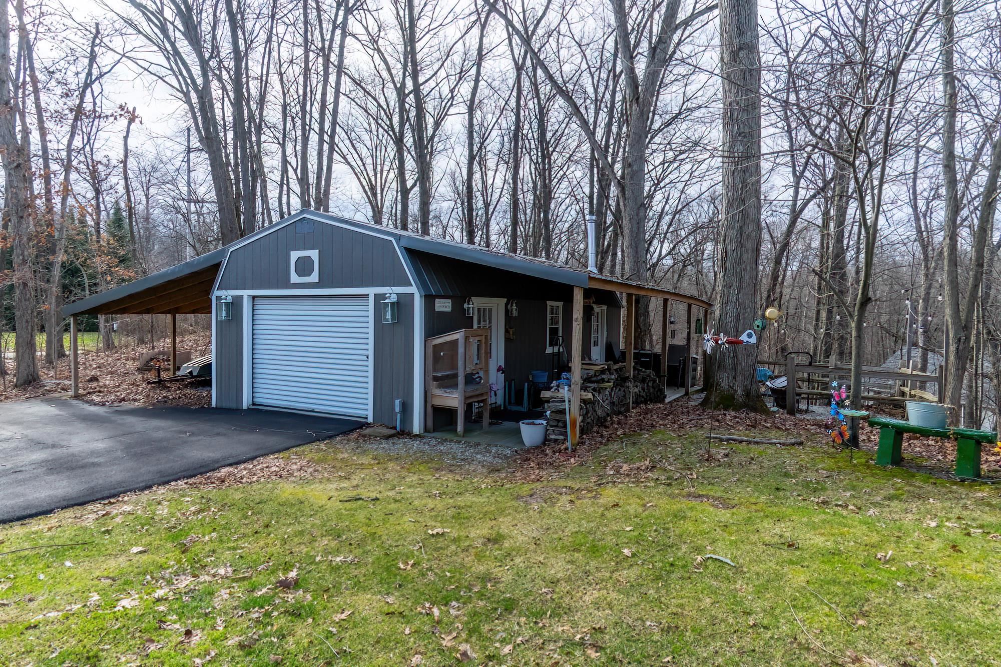 View of outbuilding featuring asphalt driveway