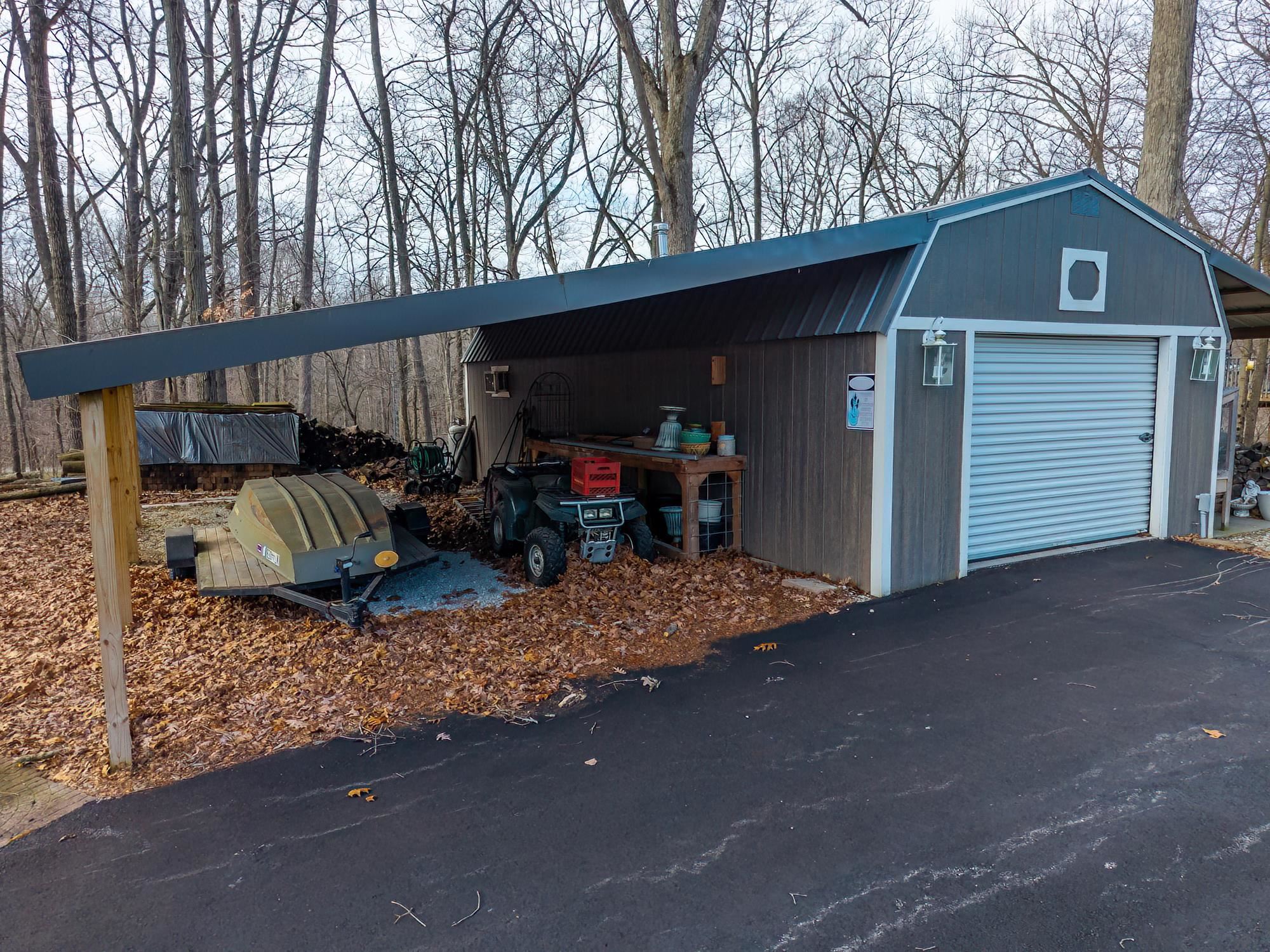 View of outdoor structure featuring asphalt driveway