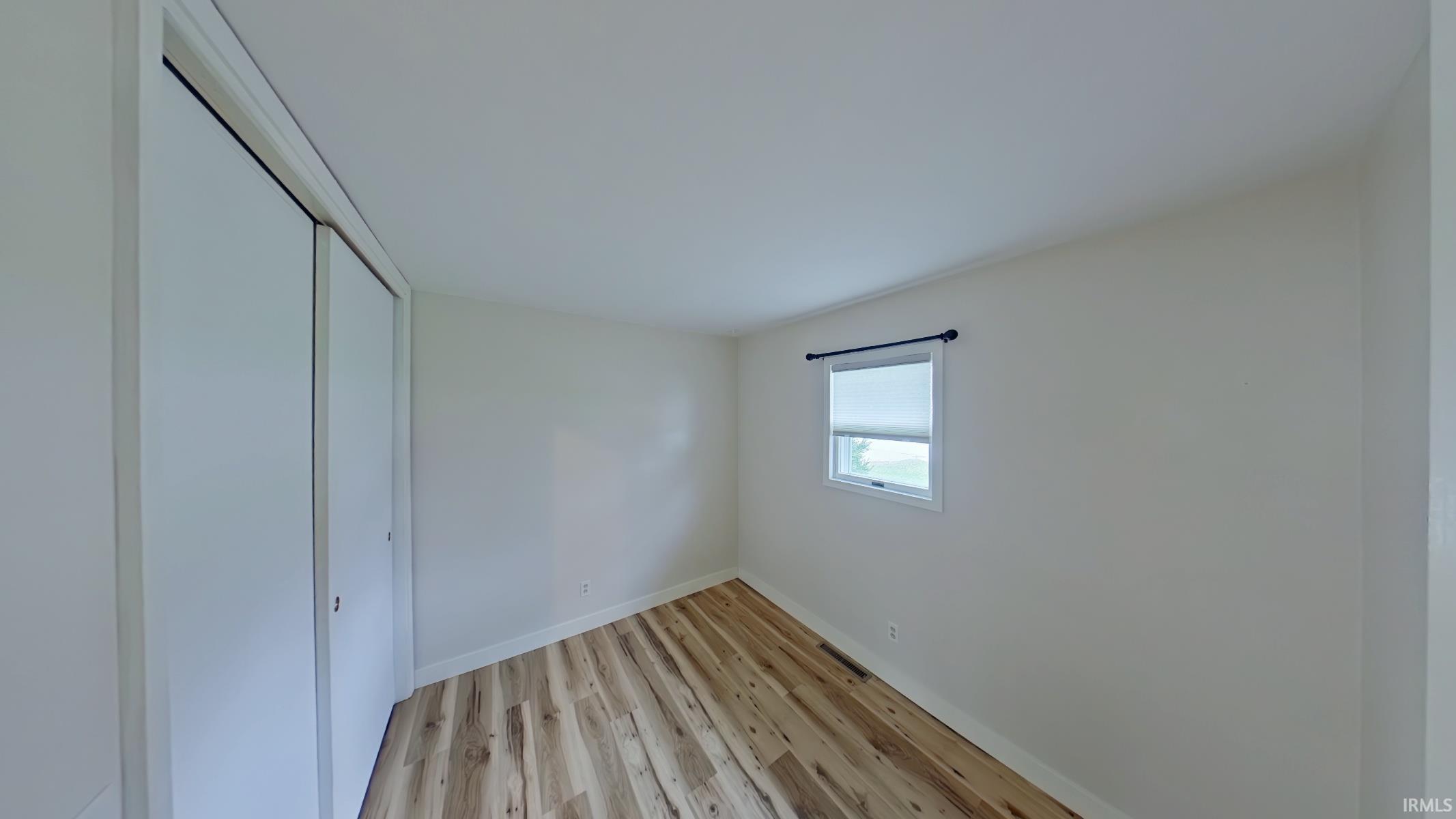 Unfurnished bedroom featuring light wood finished floors and a closet
