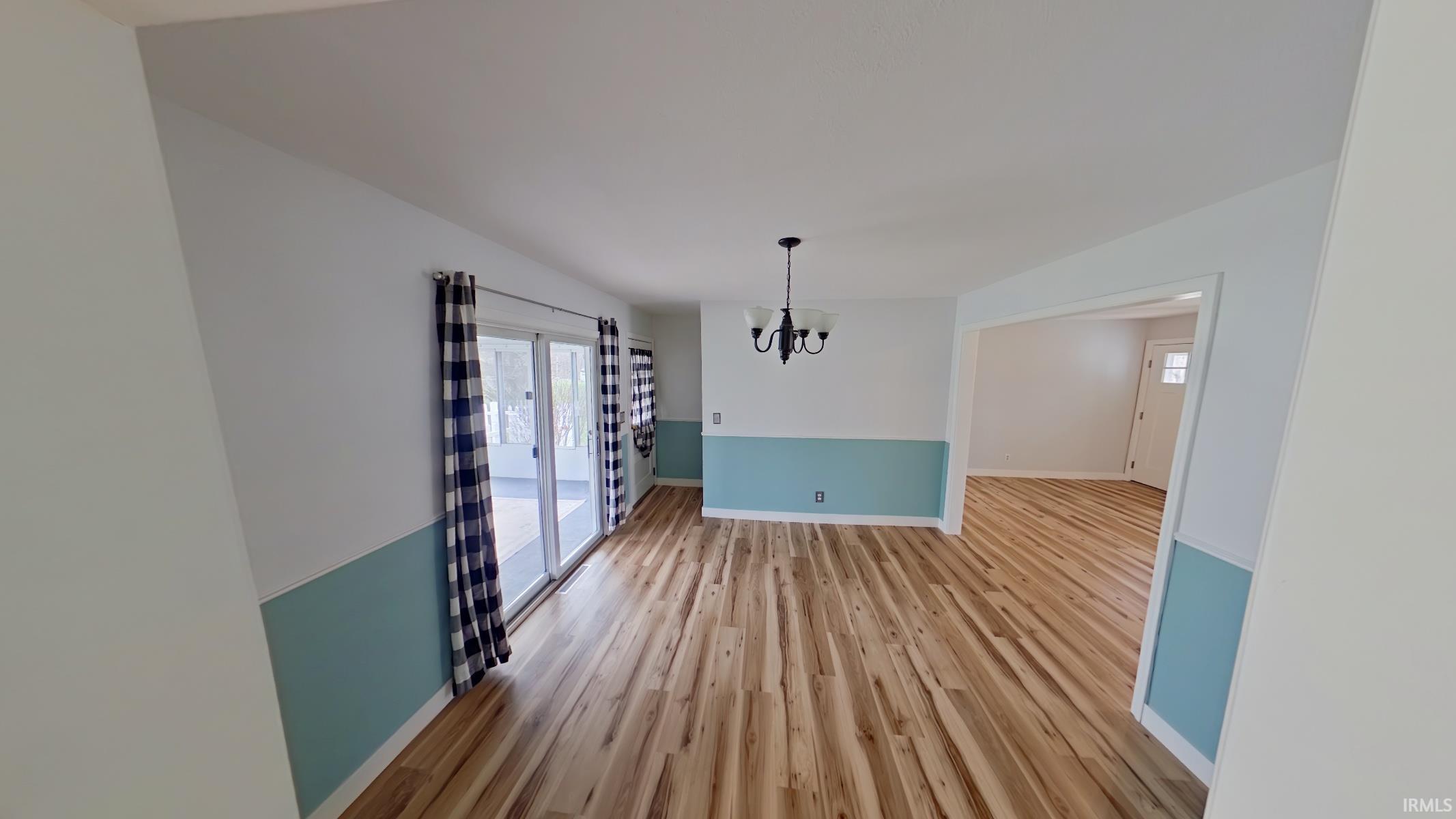 Unfurnished dining area with light wood-style floors and a chandelier