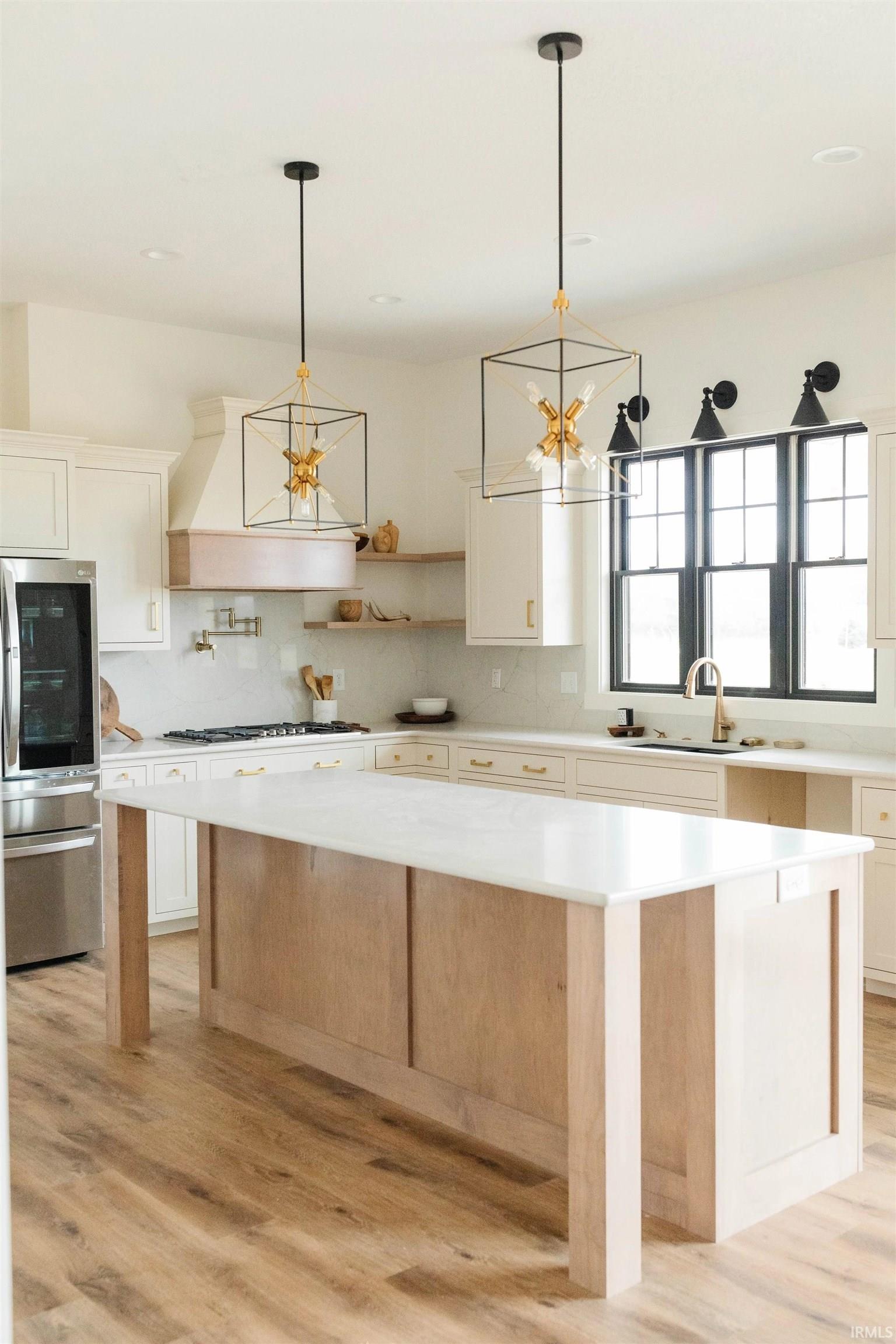 Kitchen with a kitchen island, smart refrigerator, light wood-type flooring, and white cabinets