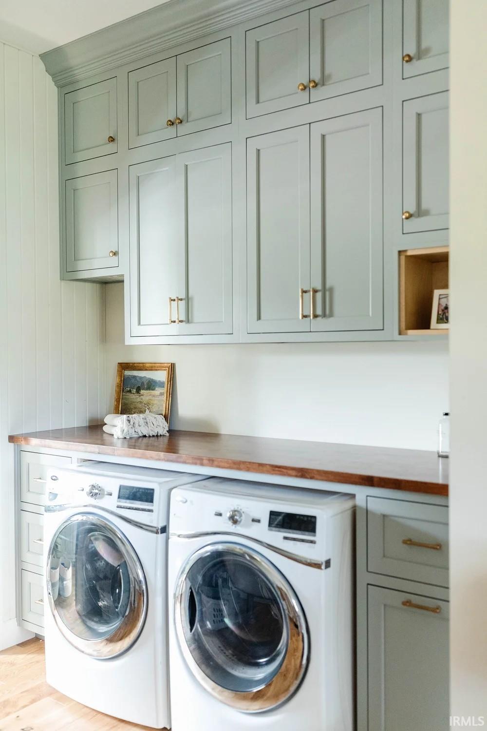 Laundry area featuring cabinet space, washing machine and dryer, and light wood-style floors