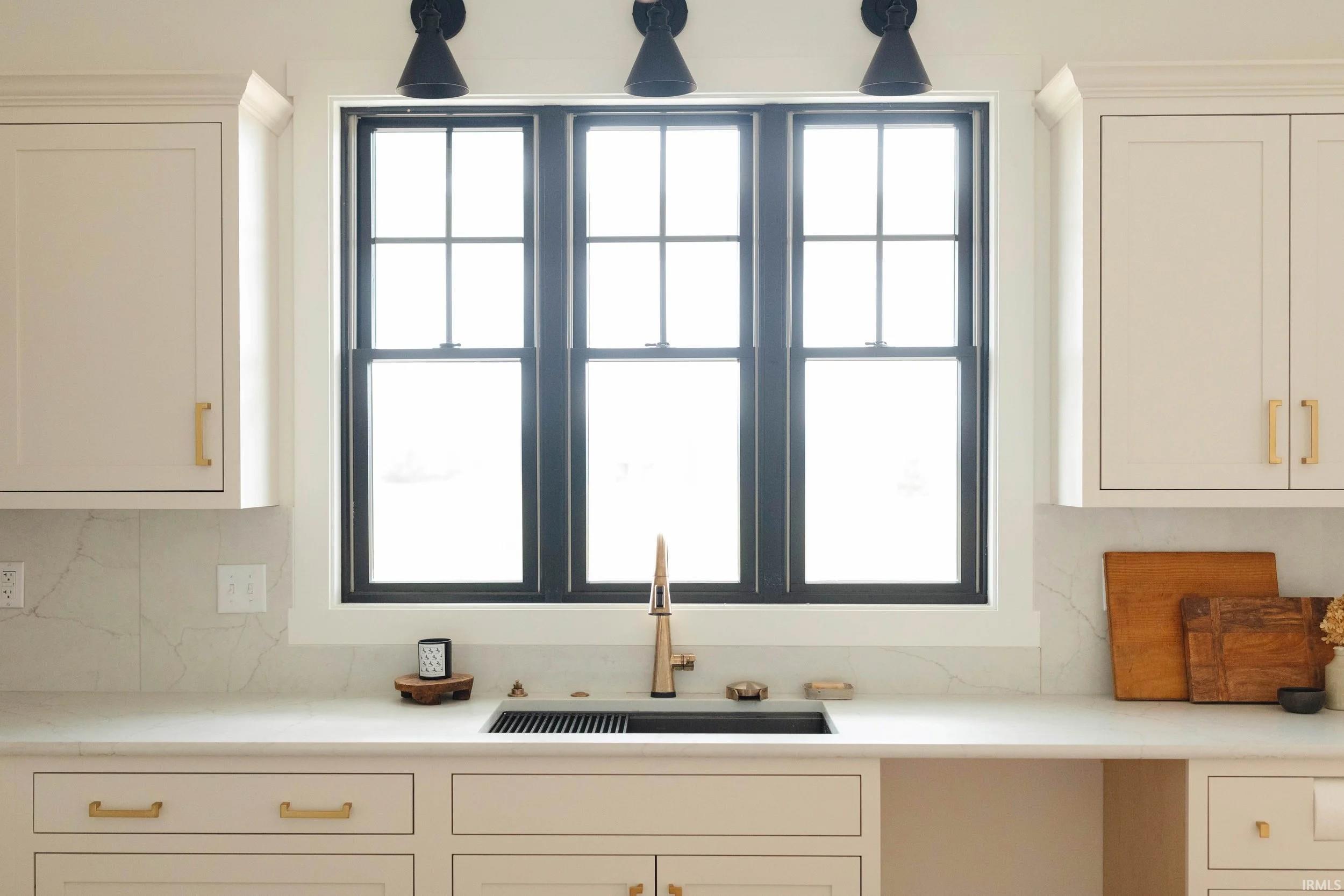 Kitchen with white cabinets, plenty of natural light, and light stone counters