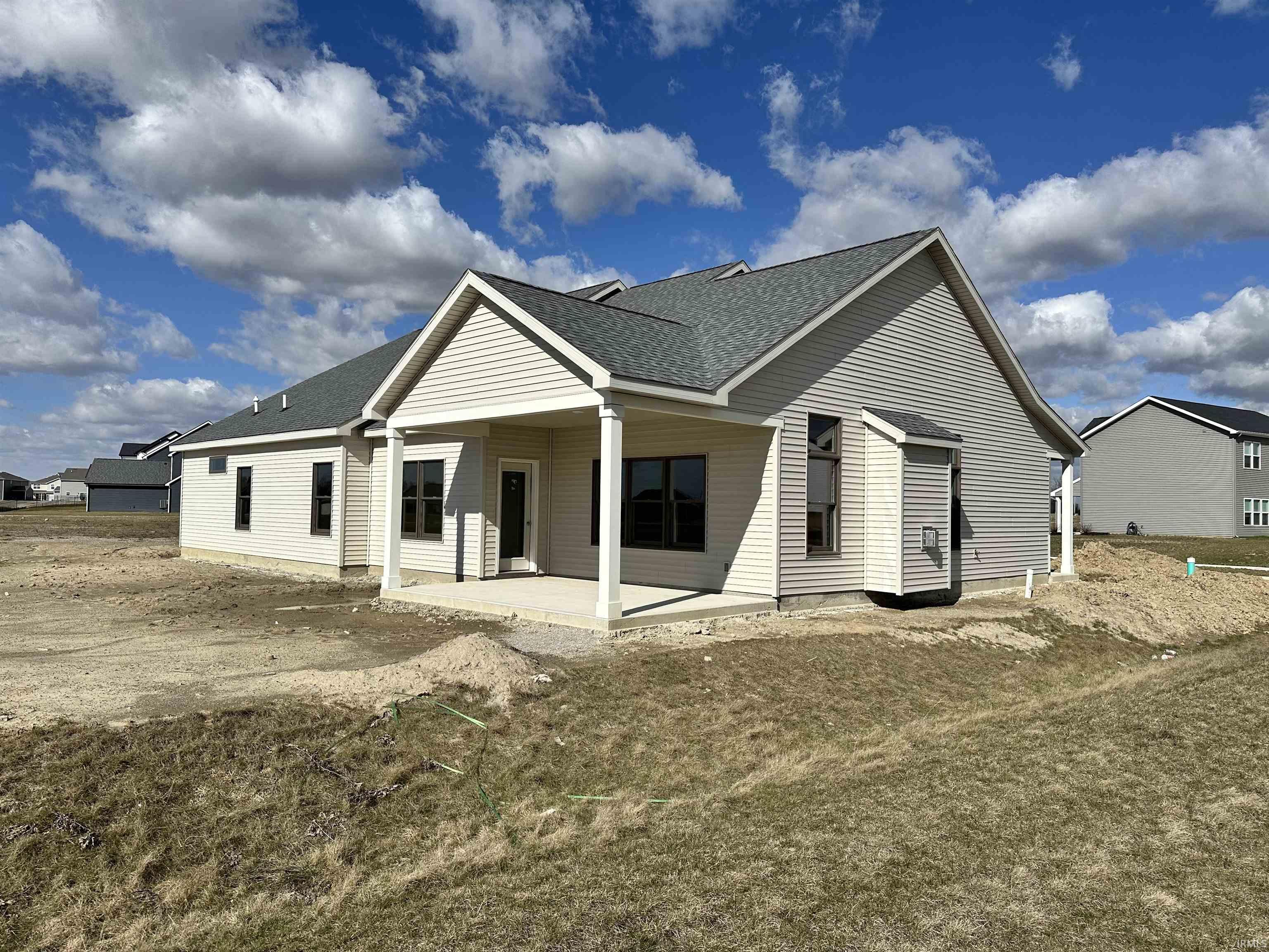 Back of property featuring a shingled roof and a patio area