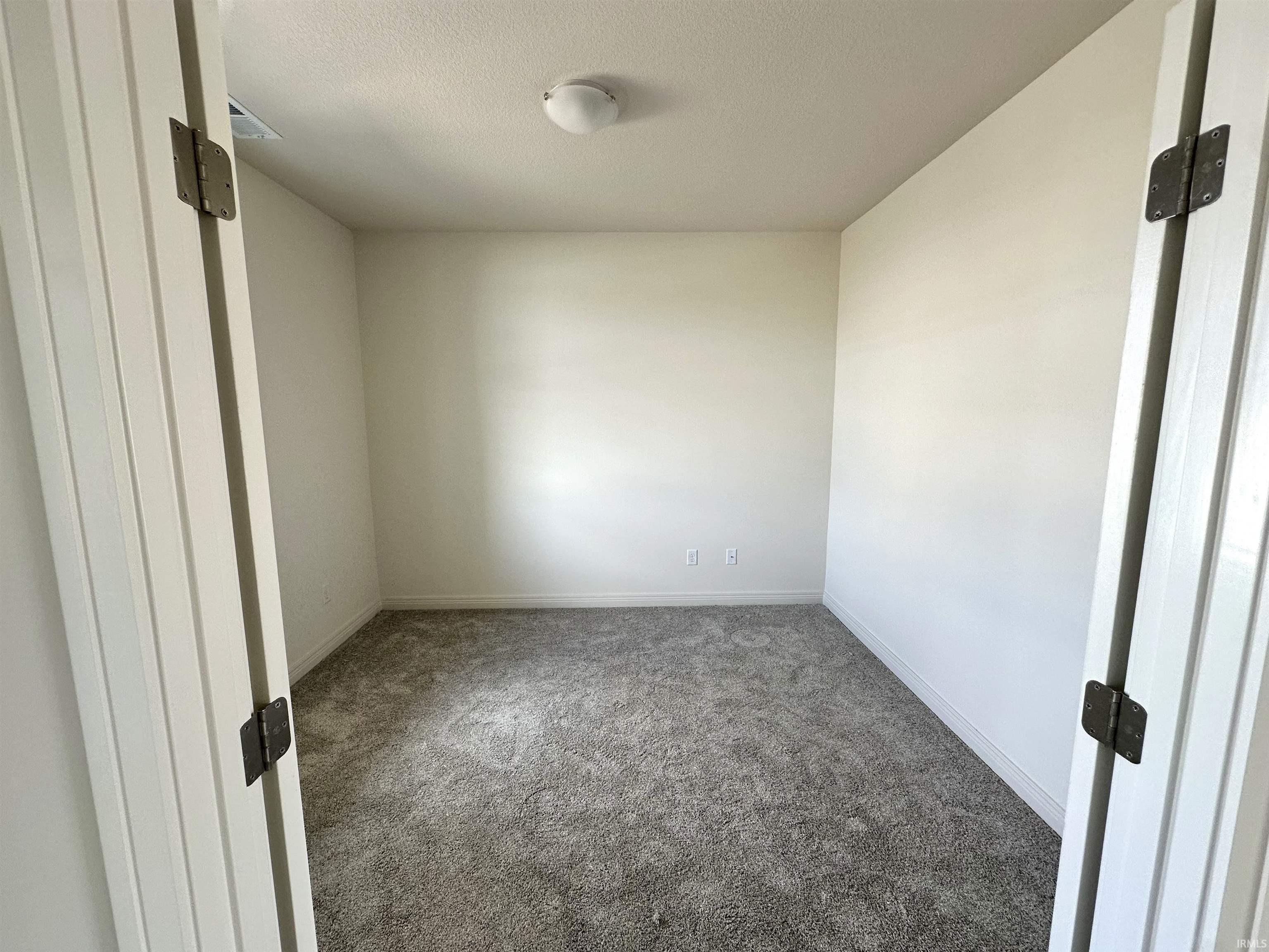 Carpeted spare room featuring baseboards and a textured ceiling