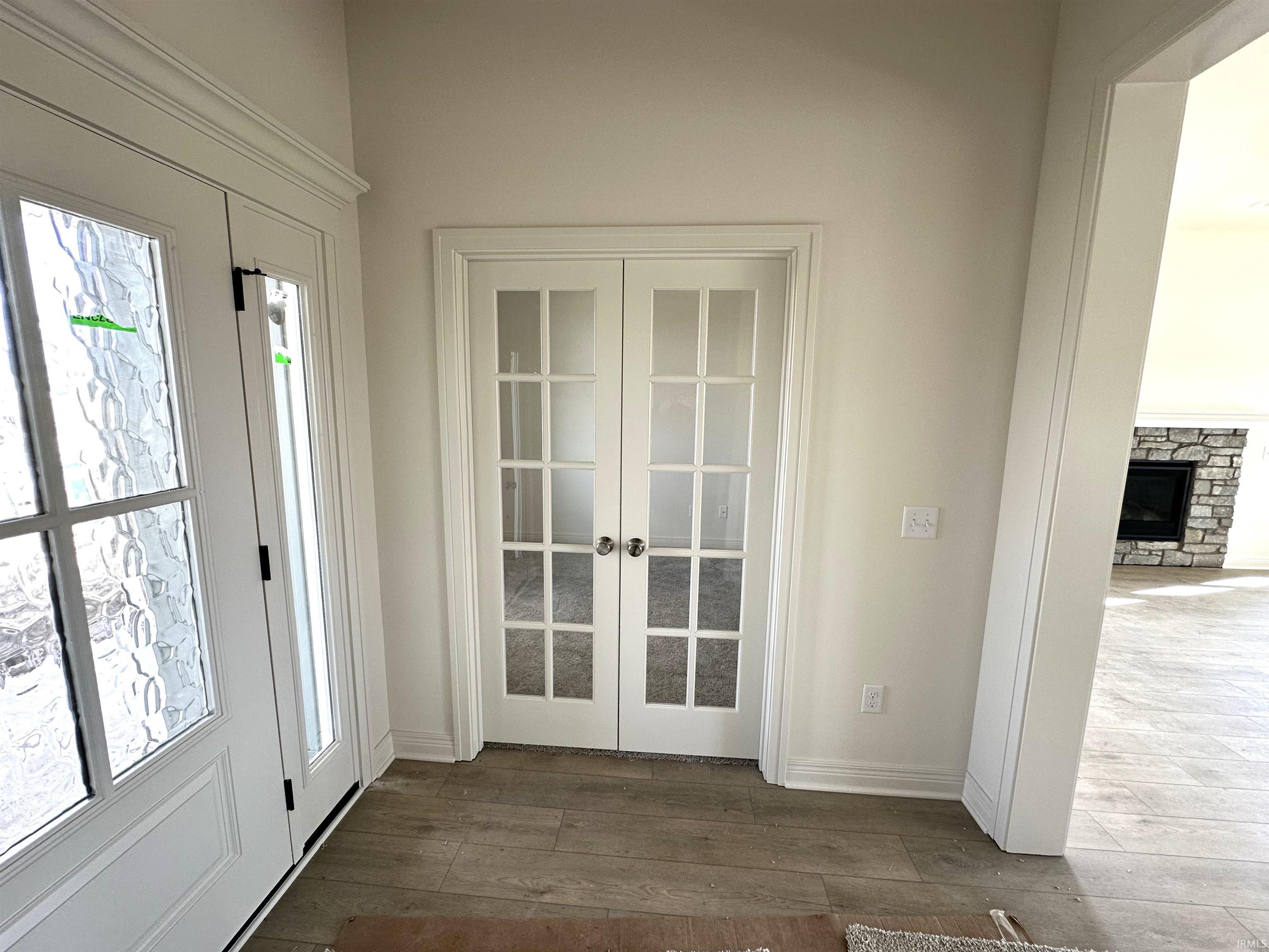 Doorway with french doors, hardwood / wood-style flooring, and healthy amount of natural light