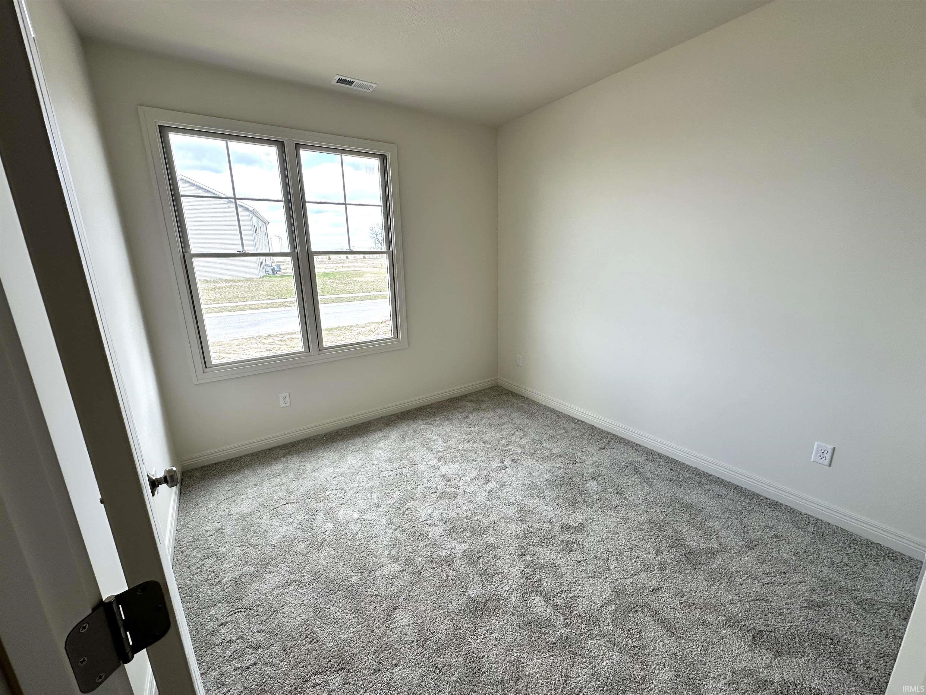 Unfurnished room with light colored carpet and baseboards