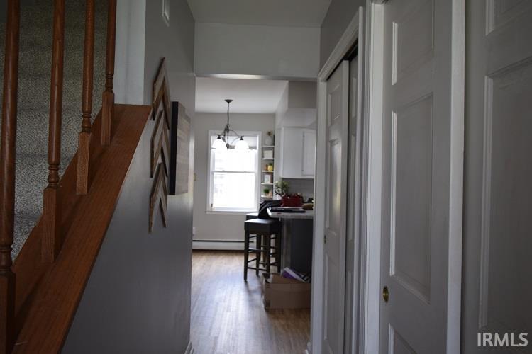 Hall featuring a chandelier, dark wood-style flooring, and baseboard heating