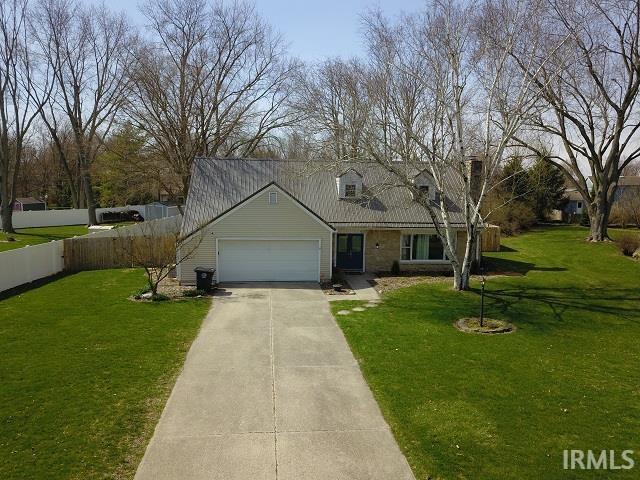New england style home with concrete driveway and a garage