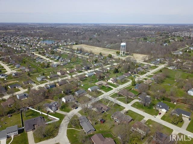 Aerial view of property and surrounding area with nearby suburban area