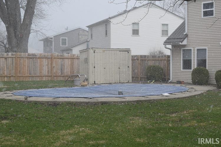 Fenced backyard featuring a storage shed and a patio