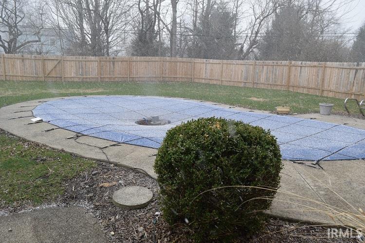 View of pool featuring patio surround and a fenced backyard
