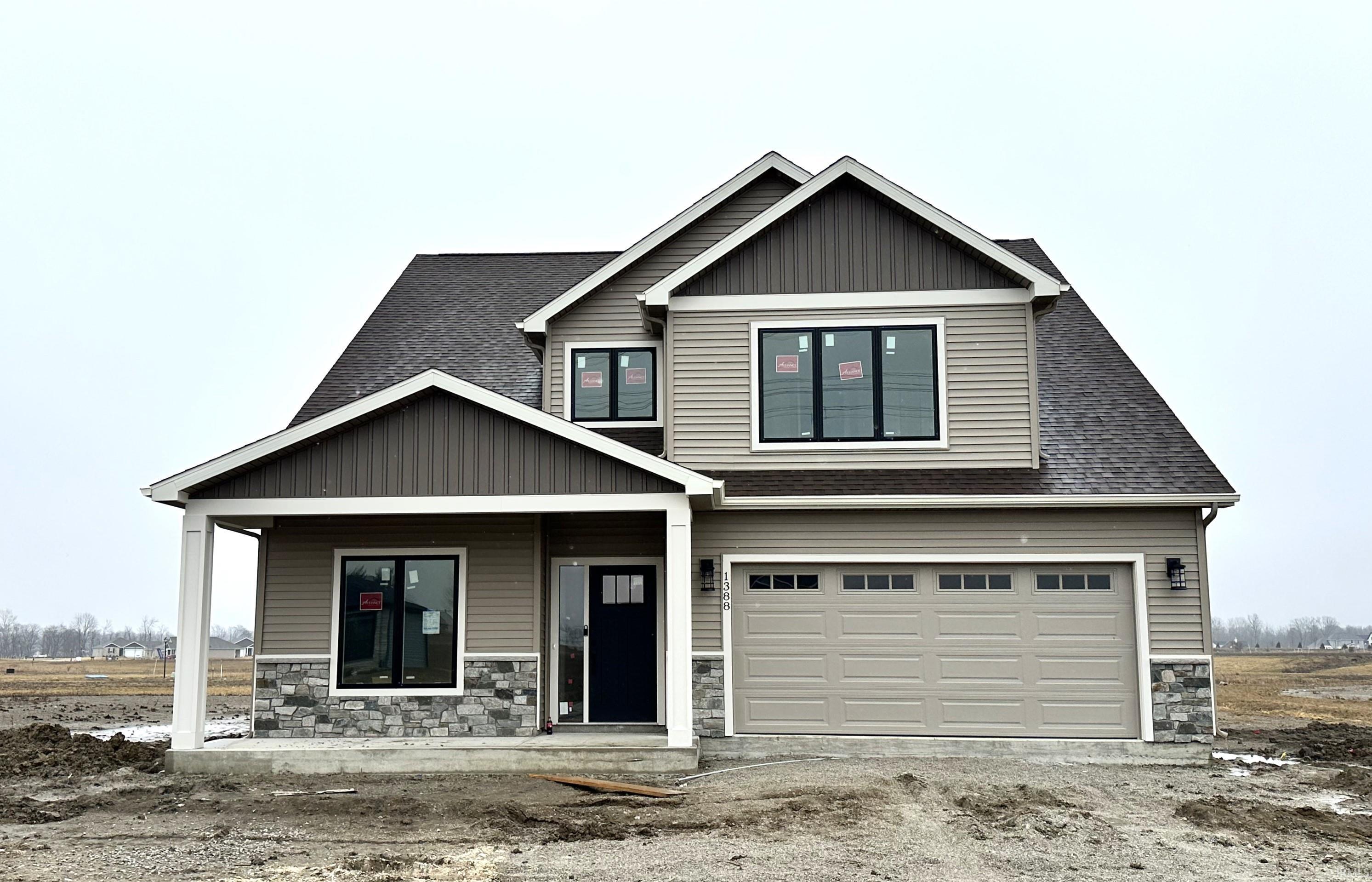 View of front of home with stone siding, a porch, an attached garage, and roof with shingles