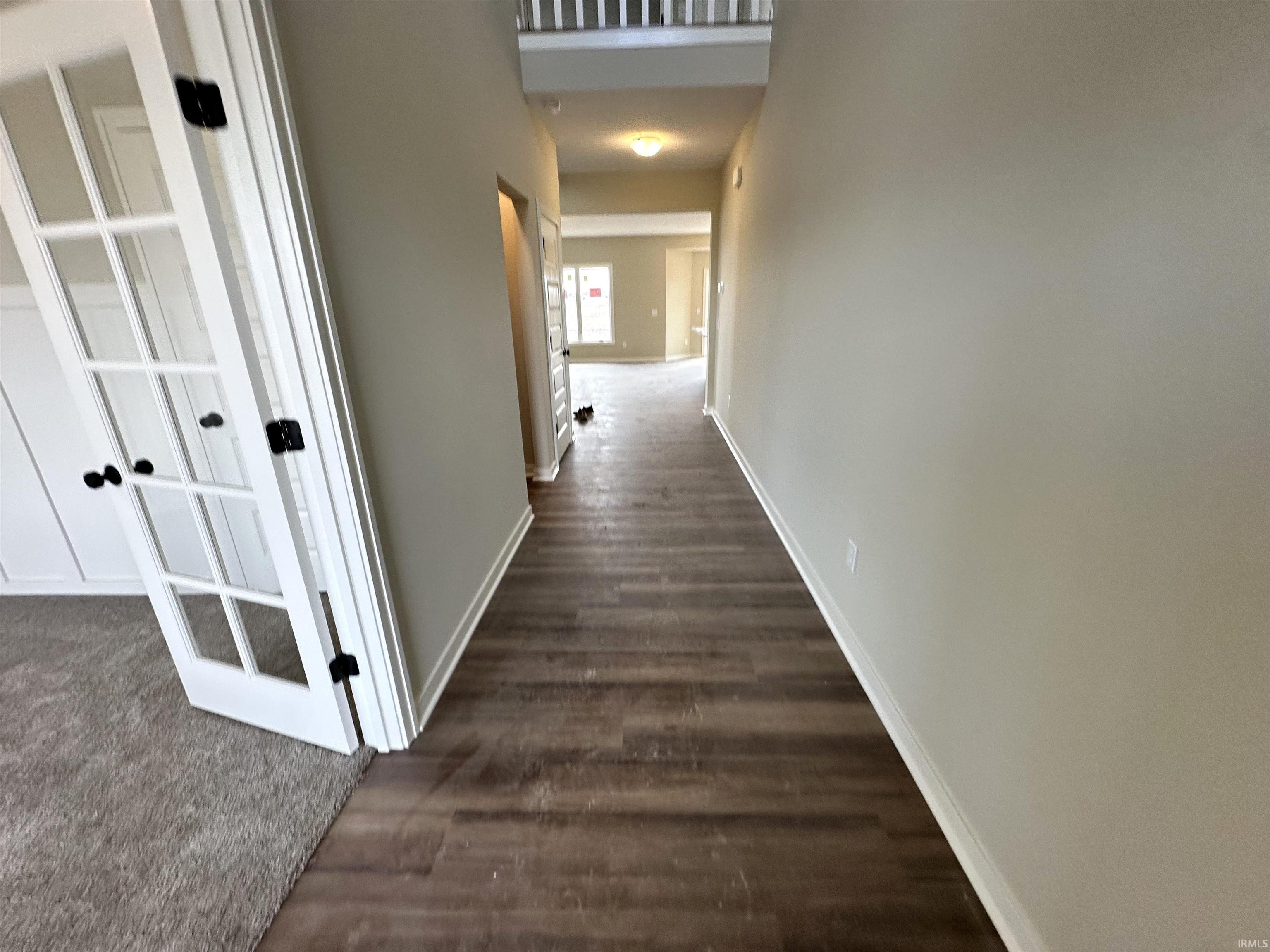 Hall featuring baseboards and dark wood-style flooring