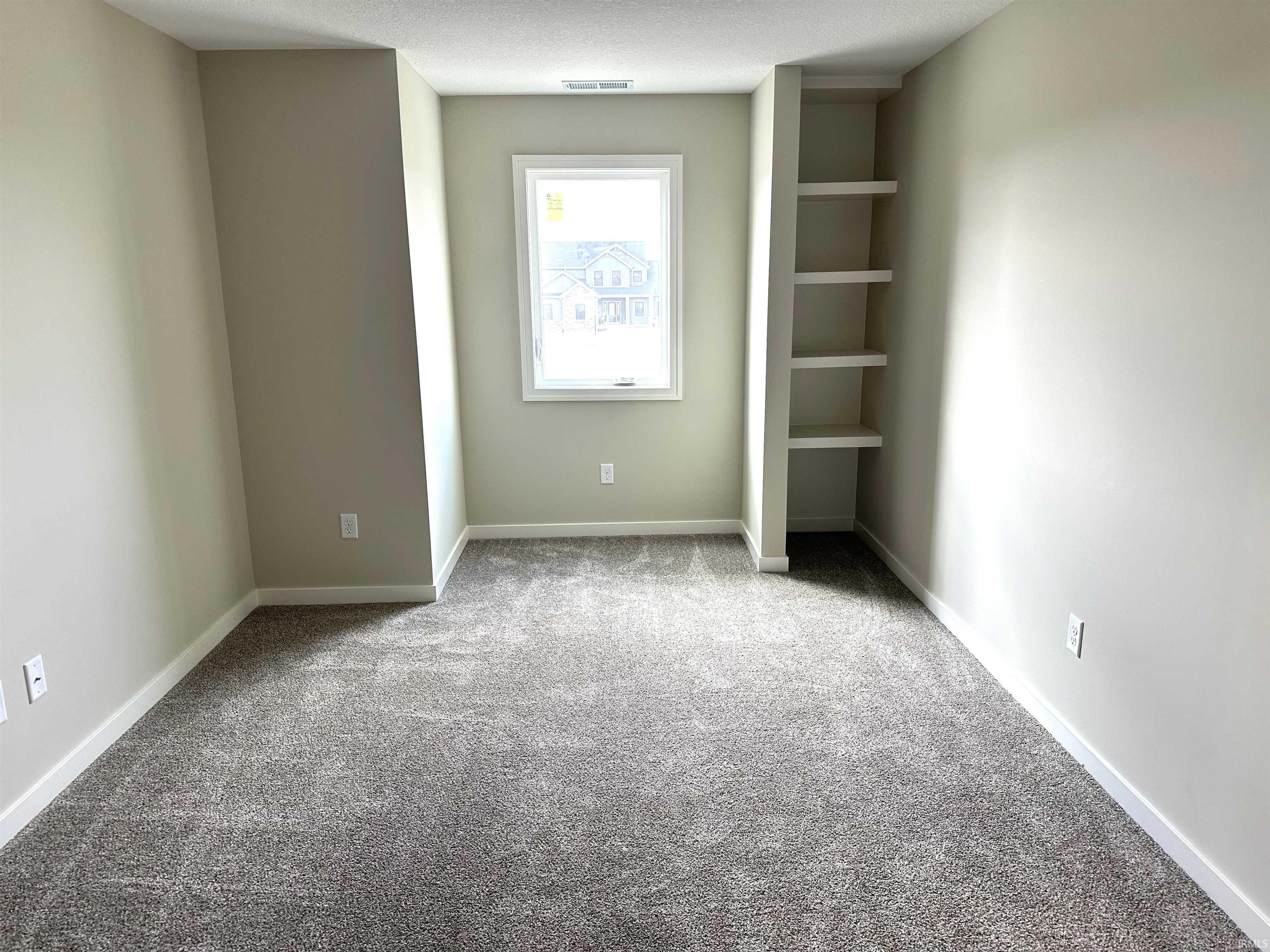 Unfurnished bedroom with light colored carpet and baseboards