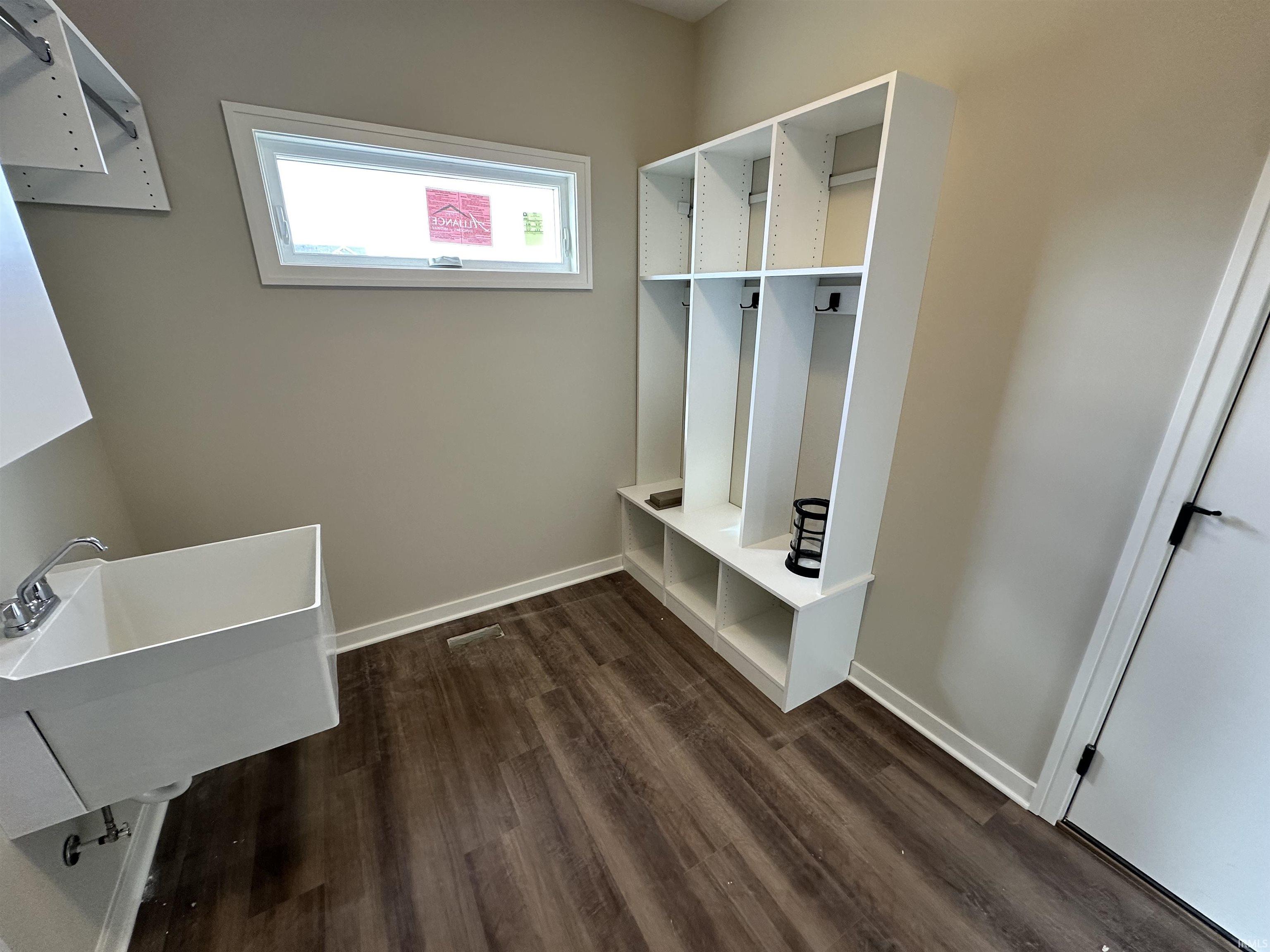 Mudroom with dark wood-style flooring and baseboards