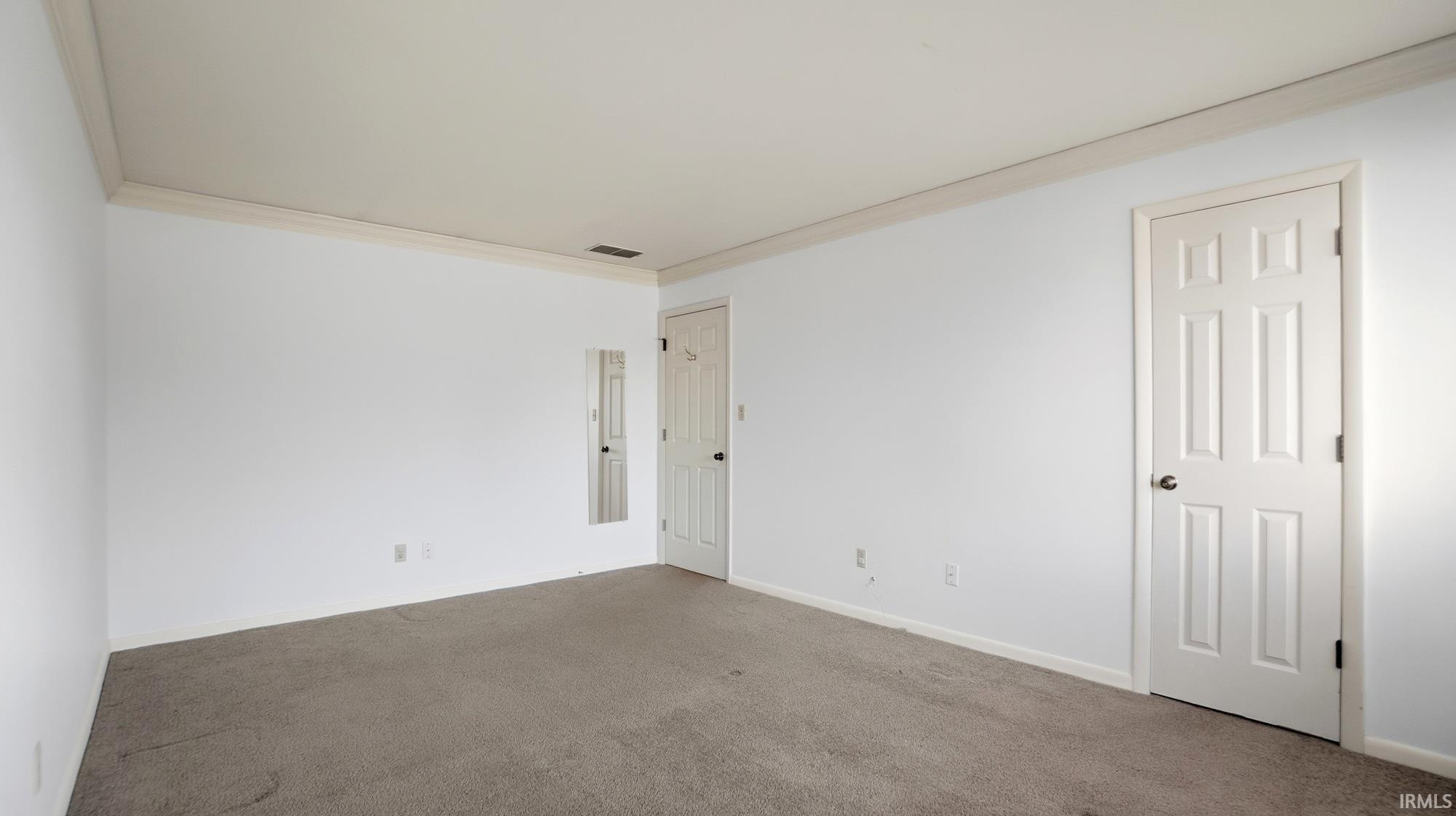 Empty room featuring ornamental molding and carpet flooring