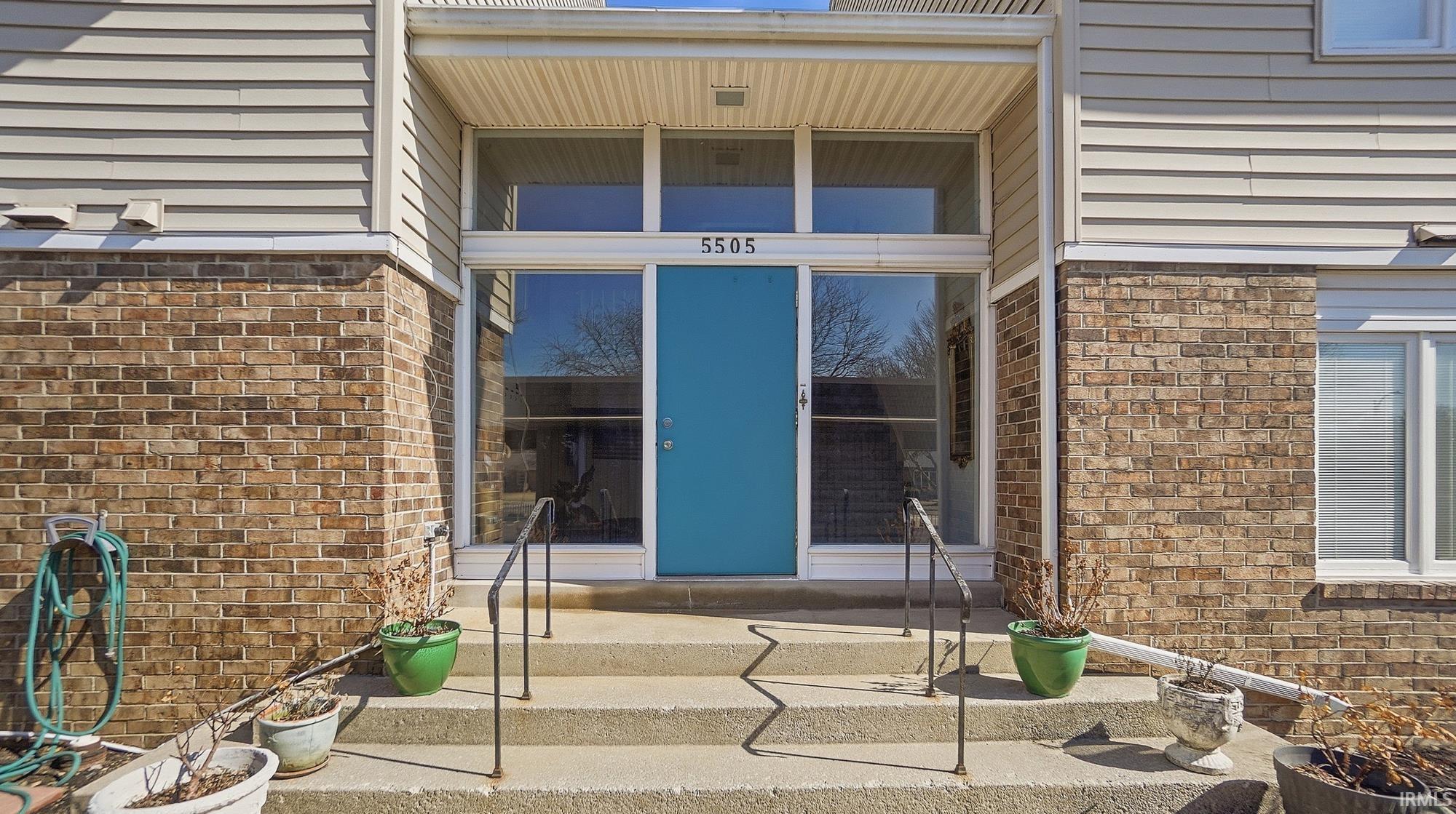Doorway to property featuring brick siding