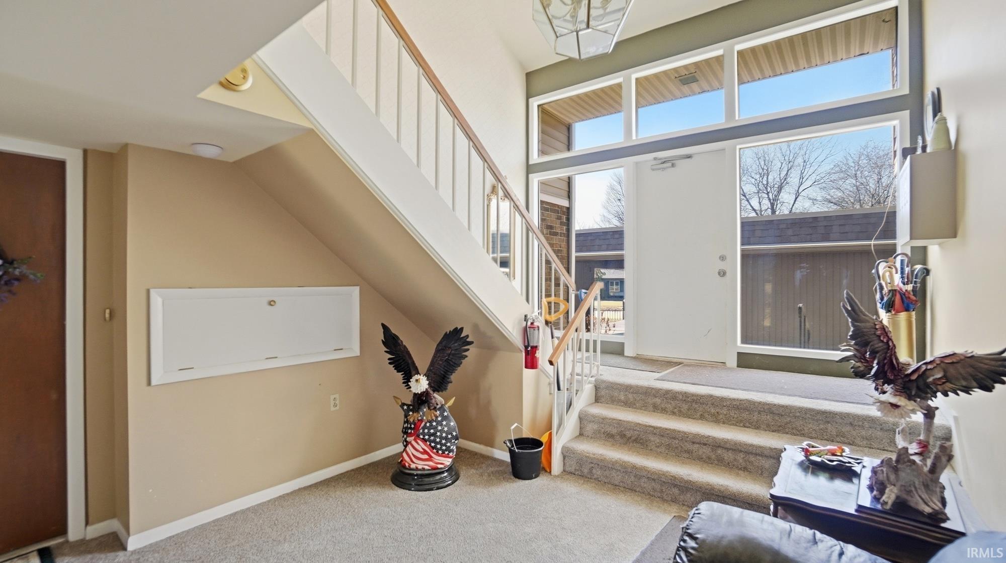 Living room featuring light carpet and a high ceiling