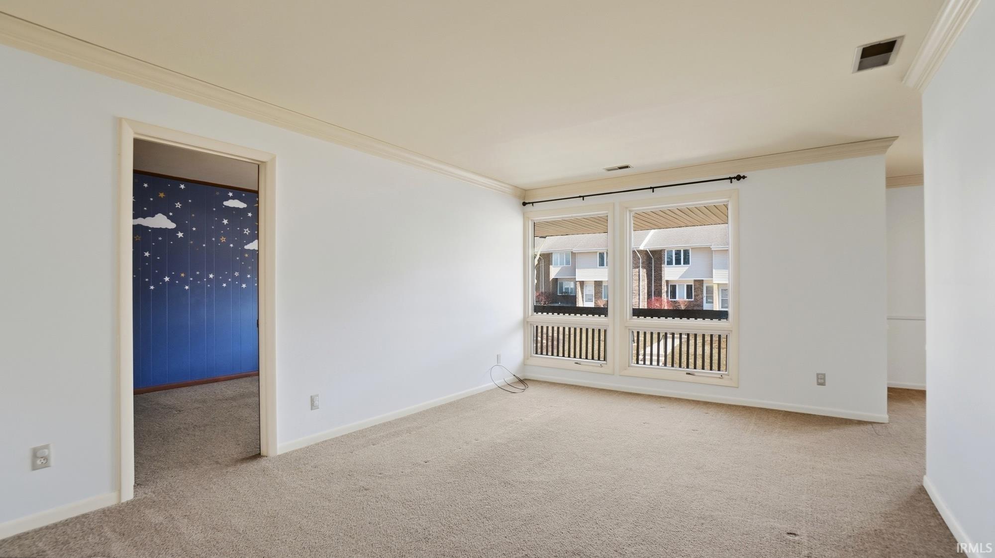 Unfurnished room with ornamental molding and light colored carpet