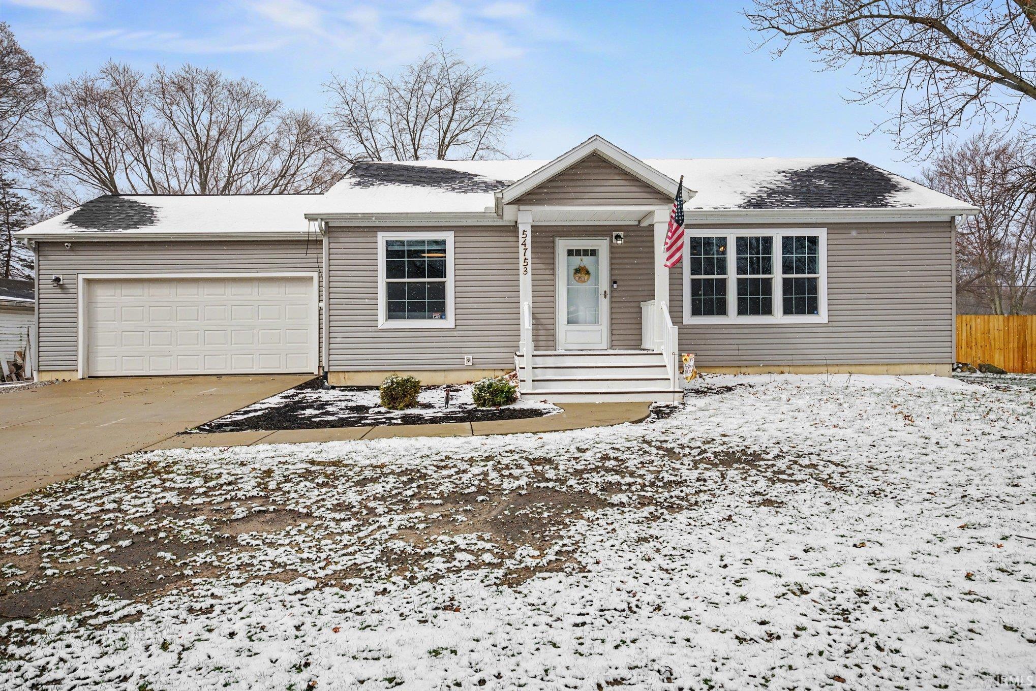 Ranch-style house with an attached garage and concrete driveway