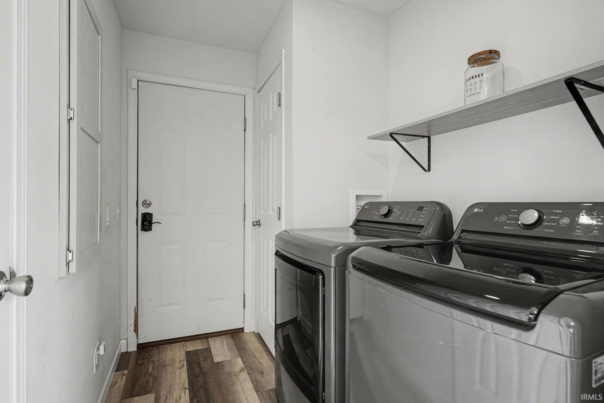 Laundry room featuring dark wood-type flooring and washer and dryer
