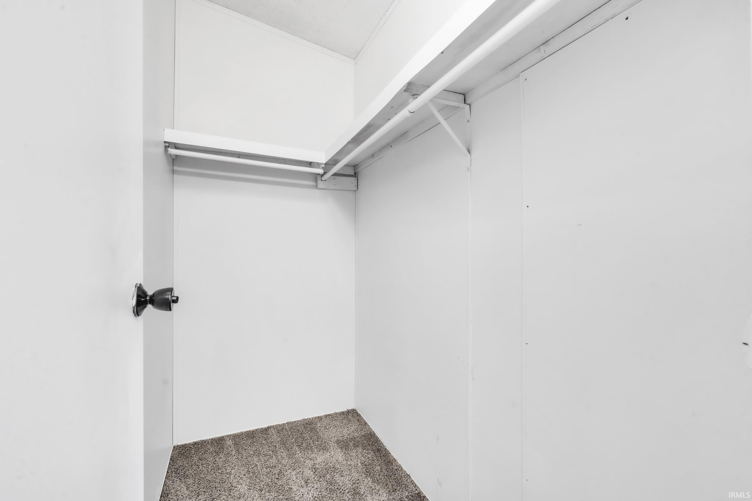 Walk in closet featuring dark carpet