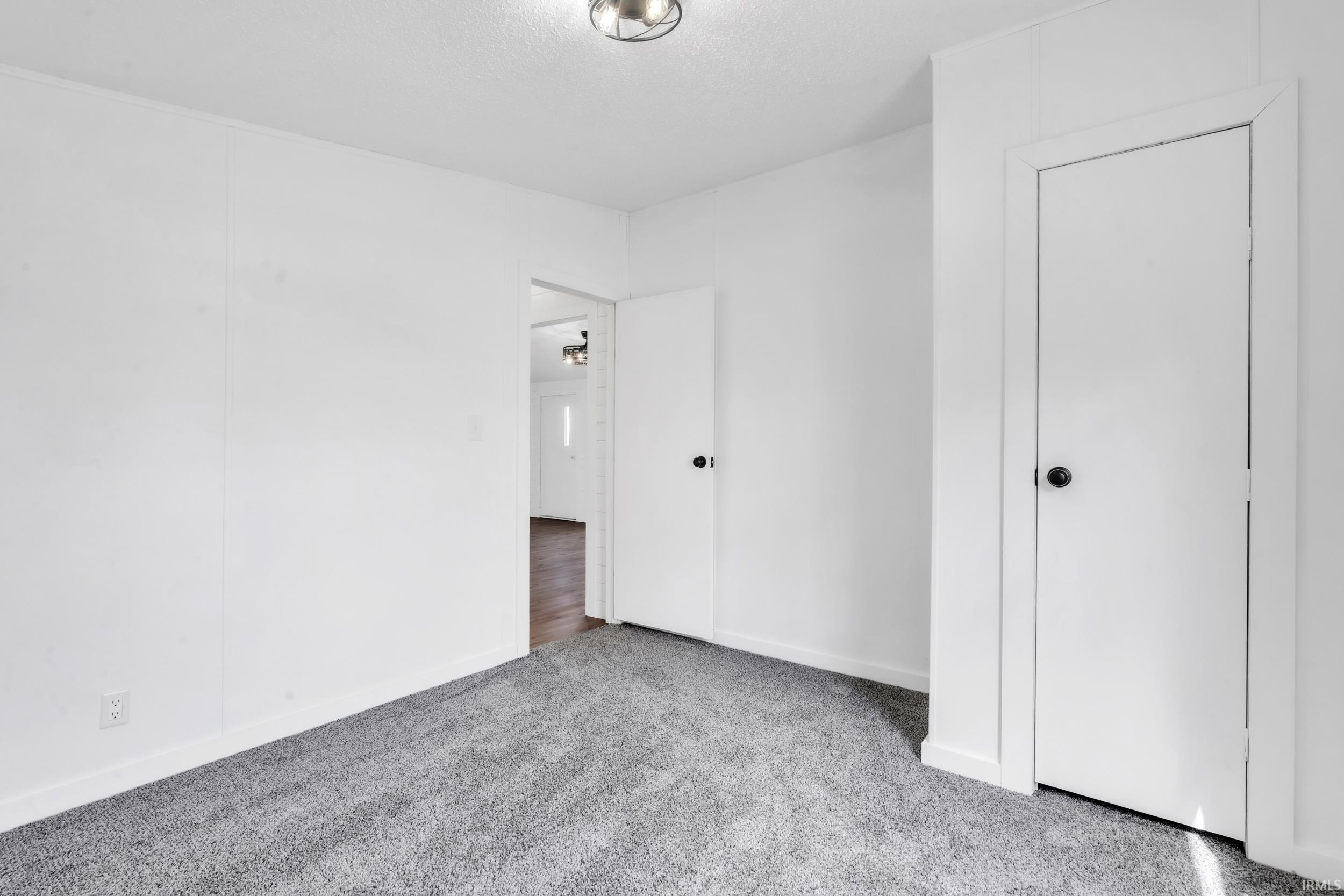 Unfurnished bedroom with carpet flooring and baseboards