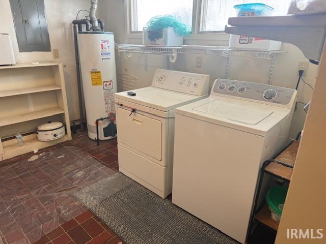 Laundry room featuring electric panel, gas water heater, washing machine and dryer, and dark floors